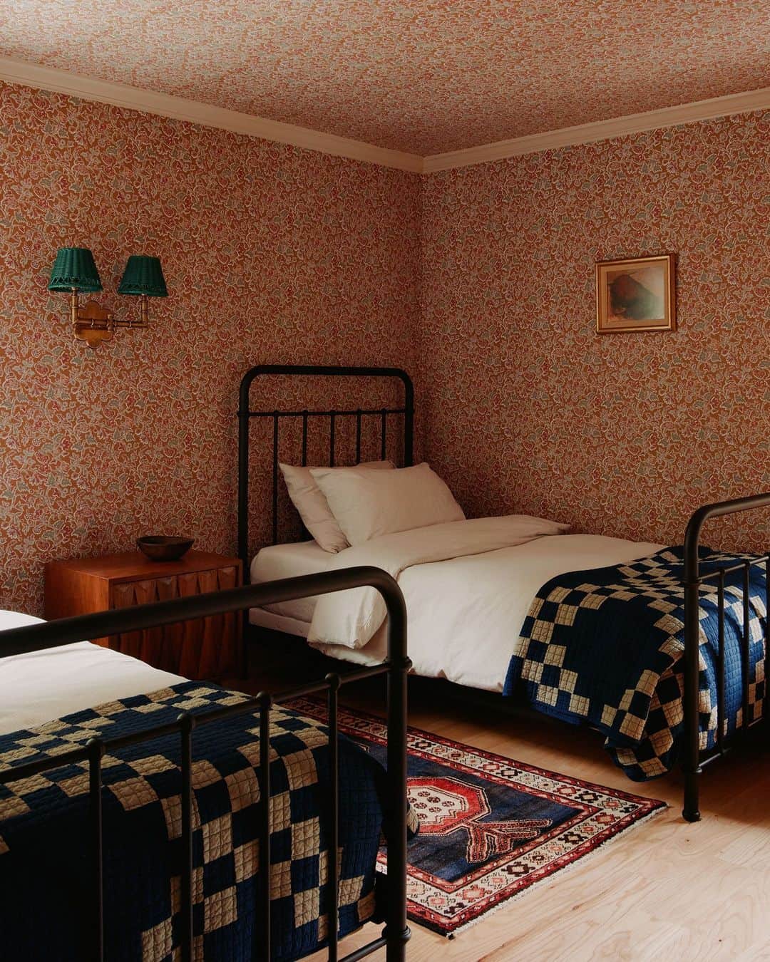 のインスタグラム：「What do you get when you merge English countryside with Hamptons summer home style? A retreat that is brimming with charm! In the guest bedroom of this Long Island cottage, designer Melissa Lee (@bespokeonly) allowed the room’s low ceilings and modest size to inform her design decisions, bringing in bold patterns with daring jewel-toned hues. “Small bedrooms are the perfect opportunity to go bold with patterns and colors that make it feel cozy and inviting,” Lee says. Here, an exuberant scrolling red wallpaper covers the wall from floor to ceiling, complemented by a pair of Japanese indigo quilts. Guests staying in this snug room may never leave!   Click the link in our bio to tour the rest of this delightful Hamptons getaway. Written by @rachelesilva_. Photographed by @william.jess.laird.」