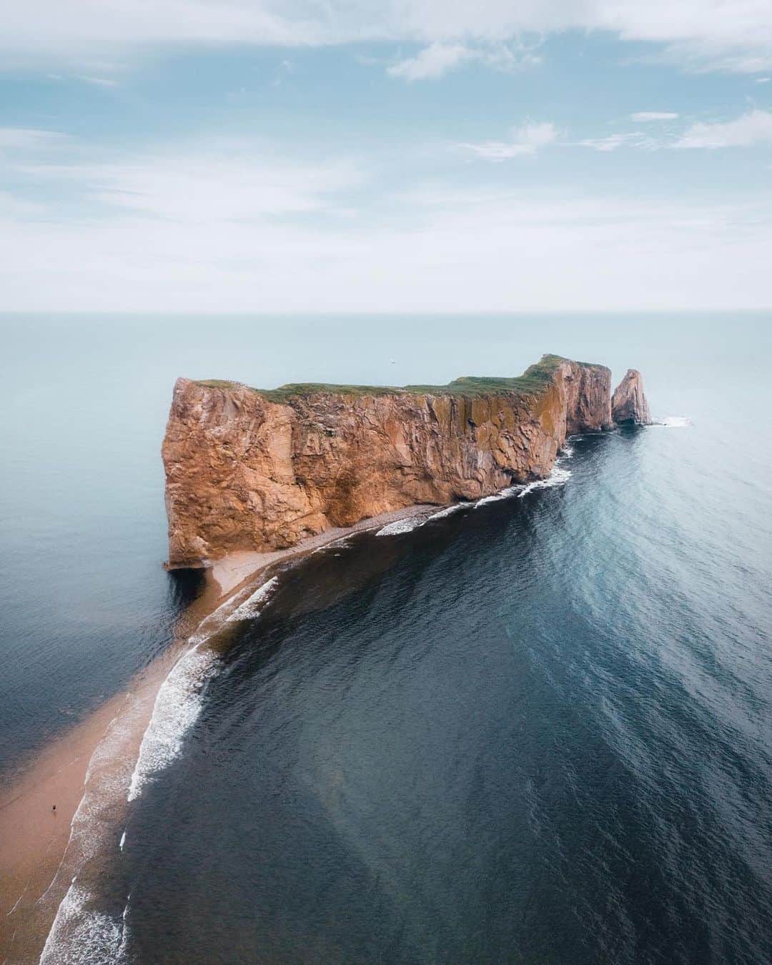 のインスタグラム：「At the end of the Gaspé Peninsula in Québec, you’ll find Percé Rock.  Nearby, you can visit the Percé UNESCO Global Geopark where you can admire a view of Percé from a glass platform suspended 200 metres (660 feet) above the ground!  📷: @yheikel 📍: @tourisme_perce, @quebecmaritime, @tourismequebec  #TourismePercé #QuebecMaritime #BonjourQuebec #ExploreCanada」