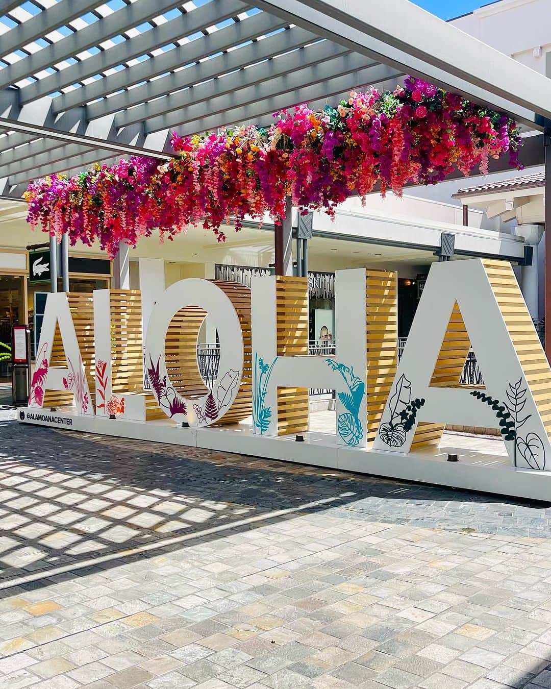 のインスタグラム：「アラモアナセンター3階、ラコステ付近に写真映えスポットが登場していました🥰 ALOHAとカラフルなお花のデコレーションがとっても可愛い！！💐  #alamoanacenter #amc #hawaii #alamoana #aloha #photospot #アラモアナセンター #アラモアナ #ハワイ #フォトスポット #写真映え」