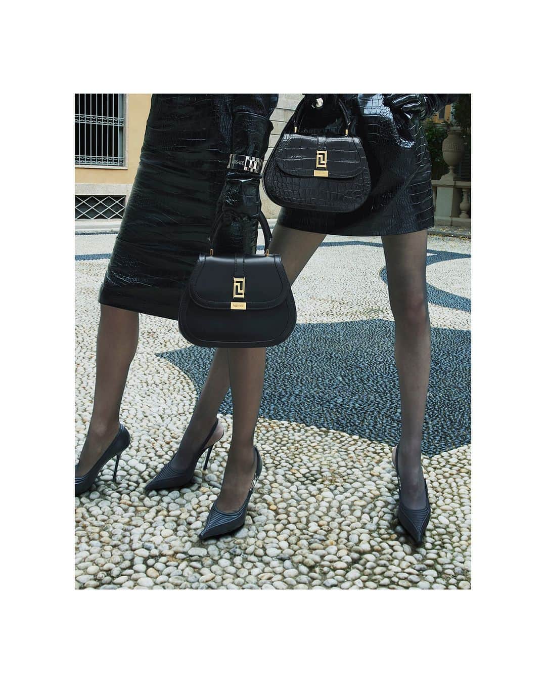 ジャンニヴェルサーチのインスタグラム：「Greca Goddess Top Handle Bag  Models wear croc-embossed leather skirt; Medusa '95 slingback pumps; Greca Goddess top handle bag  Photography by Mert & Marcus  #VersaceFW23 #VersaceGrecaGoddess」