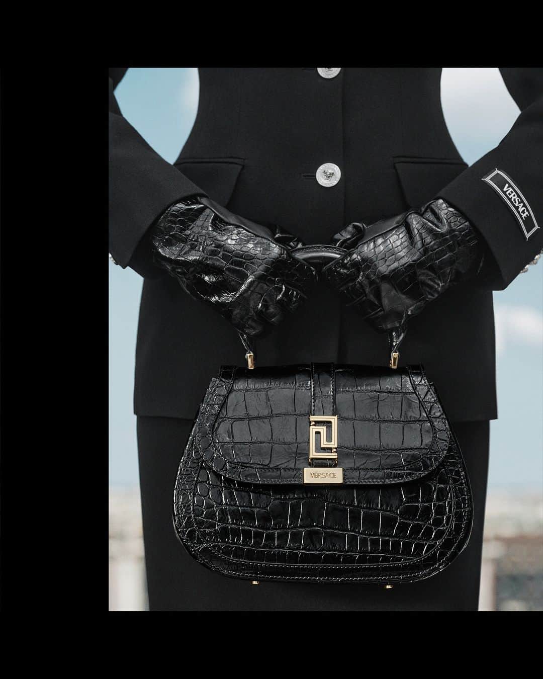 ジャンニヴェルサーチのインスタグラム：「Greca Goddess Top Handle Bag  Model wears single-breasted tailored jacket; pencil skirt; croc-embossed leather gloves; Greca Goddess top handle bag  Photography by Ilya Lipkin  #VersaceFW23 #VersaceGrecaGoddess」