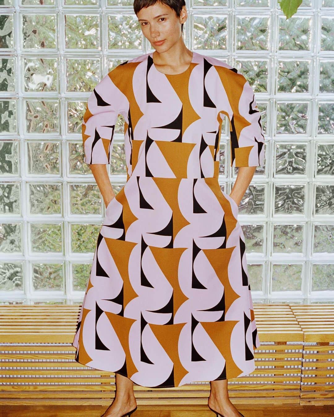 マリメッコのインスタグラム：「Great design should make you feel good. And every detail matters.   For FW23, we followed the architectural lines of glass tiles, curved surfaces, and plush pathways to craft geometric prints and clothing to layer. Like this A-line dress. Kimono sleeves and a flowing skirt are perfect for striking a power pose, reaching for the top shelf, or an after-dinner boogie.       Discover the new collection at marimekko.com. Tap the link in the bio. #marimekko #FW23」