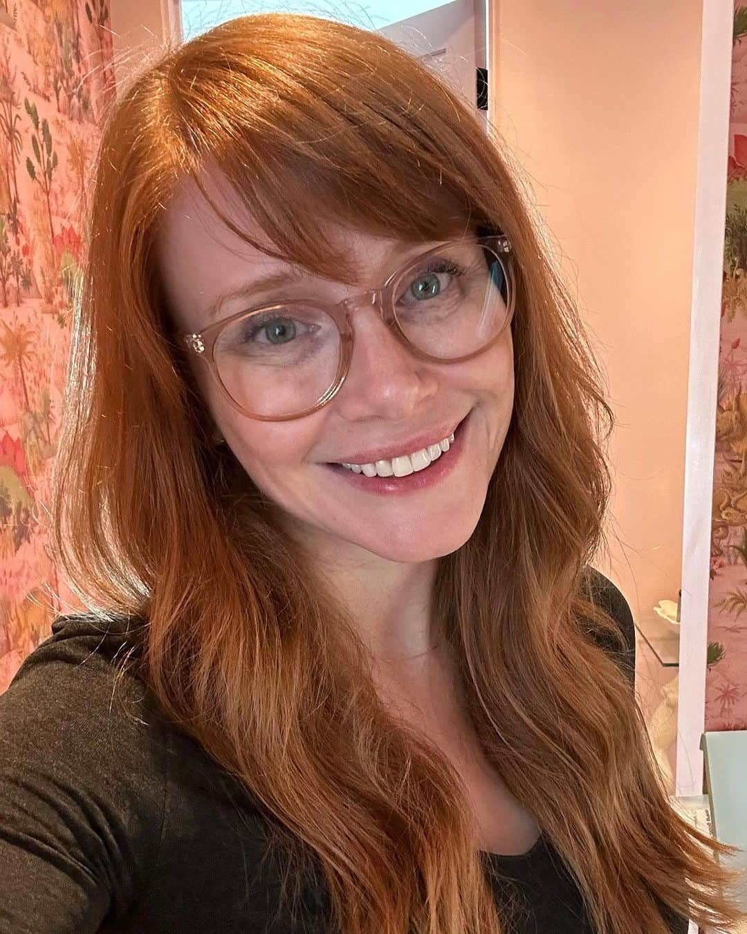 ブライス・ダラス・ハワードのインスタグラム：「For those of you following recent bang developments (thank you for your thoughts and prayers 🙏), my bangs are officially tamed! 😅 @misterjasonlow mercifully swung by to work his magic when he was in my neighborhood. ⁣ ⁣ [ID 1: A selfie of BDH in her dino-wallpapered bedroom. She smiles in celebration of her freshly cut side bangs.]⁣ ⁣ [ID 2: A post-haircut selfie with BDH (right) and the man behind the transformation, Jason Low (left).]」