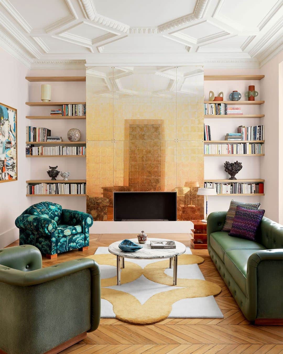 ELLE DECORのインスタグラム：「When the owner of this 1,900-square-foot duplex in Paris sought a designer to take it to the next level, designer Pierre Gonalons (@galeriepierregonalons) was the obvious choice to oversee its refresh. The result is an extension of the home’s original coziness, with what she calls “a certain eccentricity to the decor.” Gonalons’s most significant addition comes by way of the fireplace’s chimney breast, which was clad in large églomisé glass panels backed with a gradation of copper, brass, and silver leaf. The hue gets lighter from bottom to top. “My idea was to give the impression that a fire had burned the mirror at the bottom,” he says.   To see more of this eclectic city apartment, as toured in our September 2023 issue, click the link in bio. Written by @iangphillips. Photographed by @stephanjulliard.」