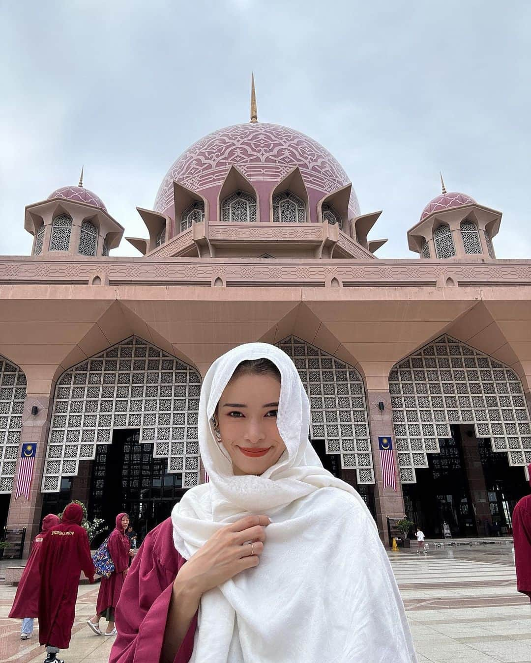 尾崎紗代子のインスタグラム：「. またモスクに🕌 こちらもマレーシア。 世界で３つしかないと言うピンクモスク。 マスジッド・プトラ。 貸し出されるローブもピンクなので 統一感がかわいい☺️  マレーシアと言えばブルーモスクだけど ガイドさんに聞いたらこちらのピンクモスクの方が 自由度が高く子連れにはオススメということで来ました。  日本語での説明書きも多くて、 読みながら感心していたところ 子供達の落ち着きが無くなってきたので 文章系は写真を撮って後で読もうと そそくさ退散。爆 「人生の目的はなにか？」 「なぜ私はここにいるのか？」 「私はどこから来たのか？」 (８枚目参照) 全て一度も考えたことが無いアンポンタンなので そういう事を考える方が多くいらっしゃるのですねえ！と 目から鱗でした。(感想ミジンコ)  そして帰り際に初ドリアン(アイスだけど)を食べて これは無理だと一口で断念。 外国の方が納豆のニオイ嗅いだ時こんな気持ちなんだろうな。笑 ドリアンは無理だ😂  しかしここも圧巻の美しさでした。  ワンオペワンオペ言ってますけど観光地 まわってるときはガイドさんが 一応近くにいます☺️  #momlife #mommylife #mommy  #育児 #ママライフ  #6歳 #4歳 #２歳 #motherof3 #motherhood  #family #familyphoto  #3人育児  #3児のママ #3児ママ  #familytime  #5人家族 #familyphotograhy #familyfirst #familytrip #Singapore #Malaysia #singaporetrip #malaysiatrip #ワンオペ旅行 #ワンオペ」