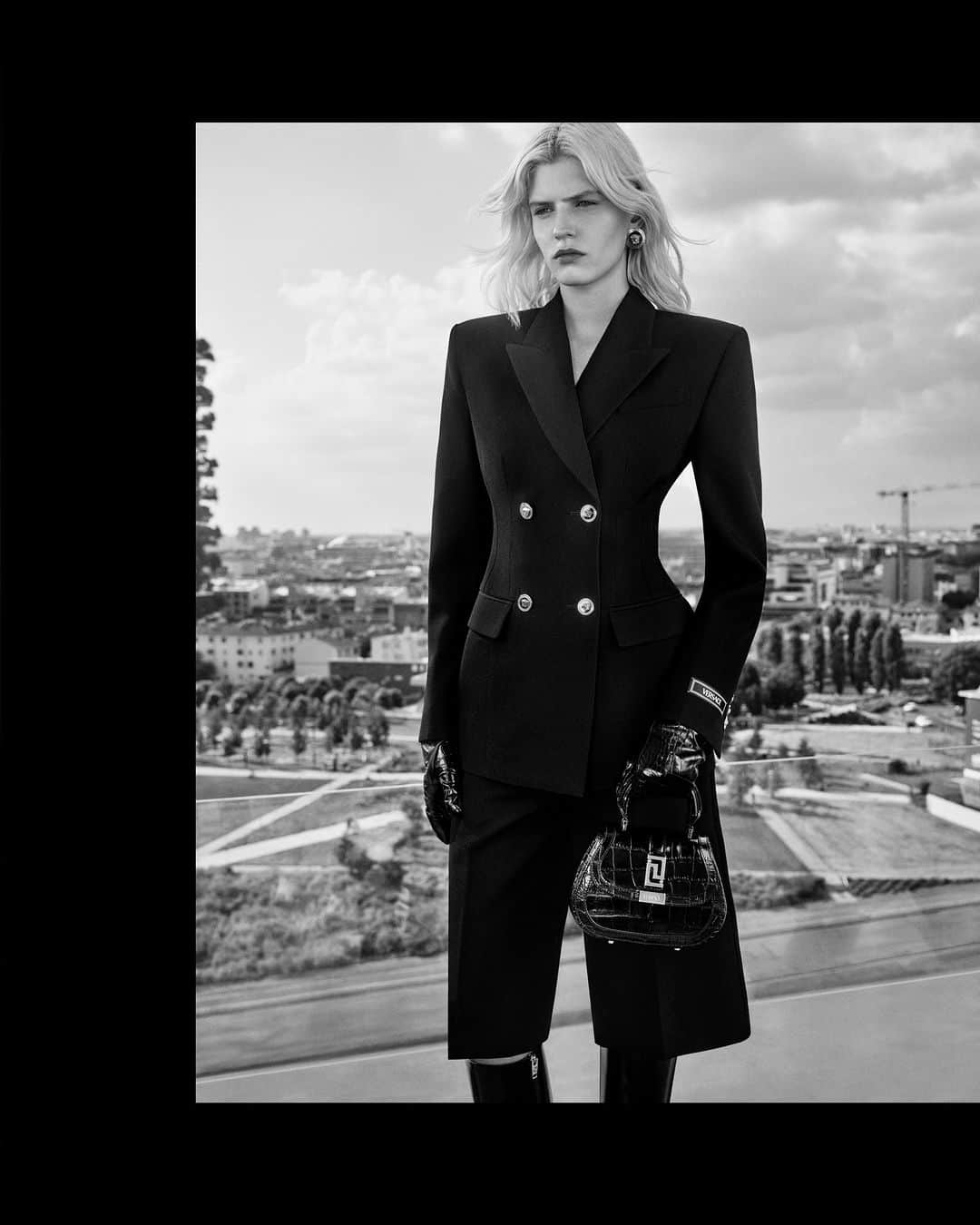 ジャンニヴェルサーチのインスタグラム：「Greca Goddess Top Handle Bag  Camille wears double-breasted tailored jacket; tailored Bermuda shorts; Vagabond boots; Greca Goddess top handle mini bag  Photography by Ilya Lipkin  #VersaceFW23 #VersaceGrecaGoddess」