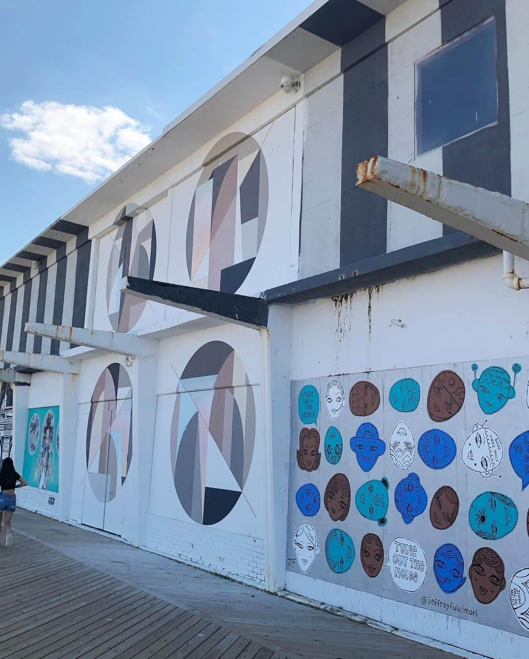 岡田育のインスタグラム：「🥂🎨🌊🎨☀️🎨⛱️ Asbury Park has a lot of historical buildings including the convention center or the carousel. The local gallerist @woodenwallsproject curated and renovated them into a huge mural exhibition. The collections may last not as long as permanent (mostly because of the ocean winds), but instead, new talented artists will stay there and paint new murals under the sun just by the shore. #woodenwallsproject  #asburyparkboardwalk  #asburyparknj  @tonysjoman  @jeffreyfulvimari  @joeiurato  @theartofpau  @hellbent_  @raygeary  @negiyakisoba  @porktomic  and more! . かつて栄華を極めたビーチリゾート #アズベリーパーク の老朽化した 建造物をそのまま残しつつ、地元キュレーターが新たに壁画展示空間として生まれ変わらせている。直の潮風に晒されるものは数年しか保たないそうだけど、するとまた新しいアーティストが描きに来る、という町おこし。」