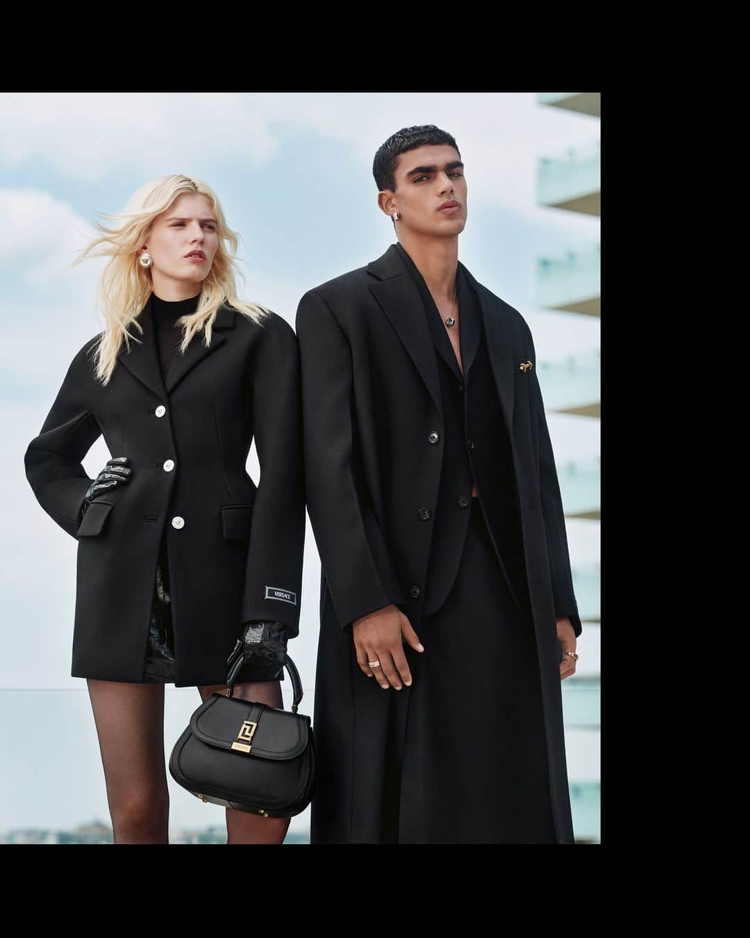 ジャンニヴェルサーチのインスタグラム：「Greca Goddess Top Handle Bag  Camille wears coat; mock-neck cashmere knit top; croc-embossed leather mini skirt; croc-embossed leather gloves; Greca Goddess top handle bag - João wears coat; single-breasted tailored jacket; skort  Photography by Ilya Lipkin  #VersaceFW23 #VersaceGrecaGoddess」