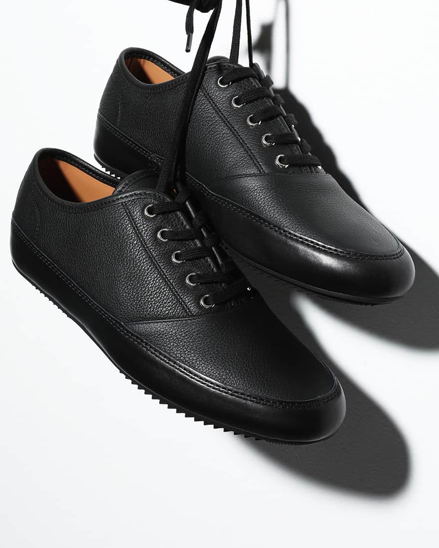 のインスタグラム：「【エディター推し】JOHN LOBB NORFOLK  ラグジュアリーブランドから注目の新鋭ブランドまで、UOMO編集部員が見つけた“推しアイテム”を紹介。  ジョンロブ新作展示会では、いつも社長の松田智沖さん直々に説明をしていただきます。松田さんの声は優しげな低音が心地よい、いわゆるイケボ。ただでさえハイクラスなジョンロブの靴の魅力が数倍増しに聞こえるのですが、秋冬新作「NORFOLK」を見た瞬間「こ、これは!?」と自分の方が声を荒らげてしまいました。  既存の「NORFOLK」はキャンバス素材に、ソールの周囲だけレザー。新作はオールレザーでオールブラックというストイックなバージョン。内羽根5アイレットにフラットレース、二本針ステッチ、フォクシングテープ風サイドソール。「もしも世界一有名なスケートシューズをジョンロブが作ったら」っていうファッション好きが夢見る「たられば」の話が現実に。  しかし素材使いやディテールの詰めはしっかりジョンロブ クオリティ。このユーモアは一過性のものかもしれないし、洒落が通じるうちに入手しておきたい。そう強く思いました。（UOMOブランド統括 山崎）  #エディター推し #JOHNLOBB #uomo #uomo_magazine #webuomo」