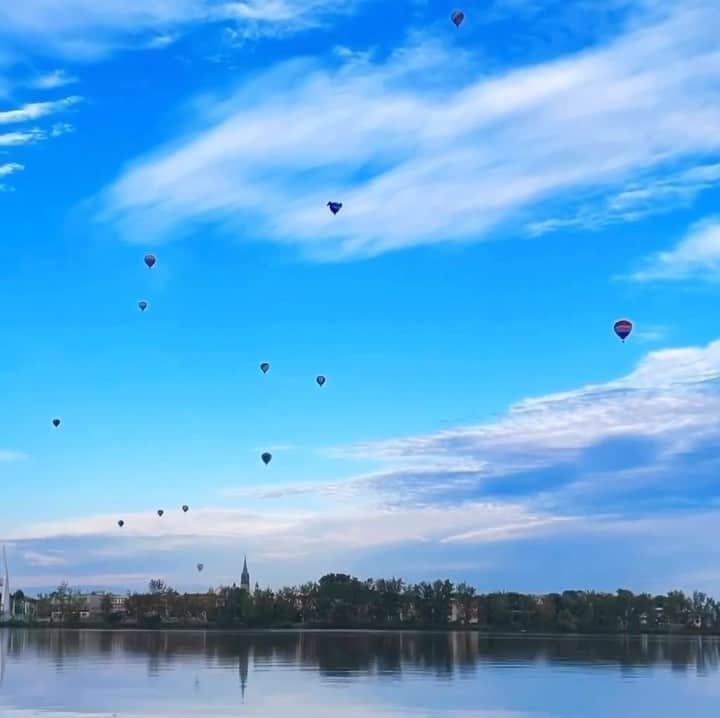Explore Canadaのインスタグラム：「“Up, up, up Can only go up from here Up, up, up Where the clouds gonna clear Up, up There’s no way but up from here” - Wise words from Canadian icon/queen, @shaniatwain    Colours take flight at the annual International Balloon Festival of @montgolfieres where an annual spectacle of 125 hot-air balloons paints the sky - the largest balloon festival in Canada.   🎥: @brown_eyed_seoul_ 📍: Saint-Jean-sur-Richelieu, @tourismequebec   #BonjourQuebec #ExploreCanada    Video description: A timelapse of hot air balloons seen from across a lake launching and streaming across a blue cloud-swept sky.」