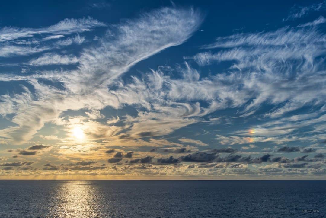 KAGAYAのインスタグラム：「羽毛が舞っているような雲たちに見とれていると、虹色の幻日が現れました。 太陽から少し離れたところで虹色に光っているのが幻日という現象です。 （今週、石川県能登半島で撮影） 今日もお疲れさまでした。」