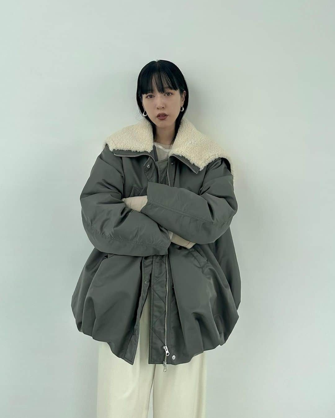 AICOさんのインスタグラム写真 - (AICOInstagram)「アウター先行予約アイテムのご紹介です。  BALLOON DESIGN HOODED N3B 着用size1 今季のアウターを考えている時に、随分久しぶりになっていたミリタリーアウターを作りたくなり色々考え始めました。ベースになるモデルからどうアレンジしていくか。色々模索しながらN3Bをベースにバルーンディテールをくわえたデザインに仕上げました。バルーンディテールを入れる事で丸みのあるシルエットにし、ミリタリーアイテムを女性らしく仕上げました。ポケットディテールは縦に長い胸ポケットのみにし、ミニマルにデザイン。中綿が入っているので暖かく、袖口には防風効果を出す為に中をリブ仕様にしています。フロントジップは逆開仕様。フーディーは中心にファスナーが付いており開閉可。フードの中はボア仕立てなので被るととても暖かいです。カーキの色にも拘り、グレイッシュな色味にする事でカジュアル過ぎずモダンな印象で着て頂けます。真冬まで着て頂ける防寒効果のあるアウターです。とてもCLANEらしいデザインに仕上がり満足しています。展示会でもとても人気を頂いたコートです。流行りのないアイテムだからこそ長く愛用して頂けます。 #clane #outer #先行予約会 #clane23awouterpreorder」8月17日 17時14分 - aico00000