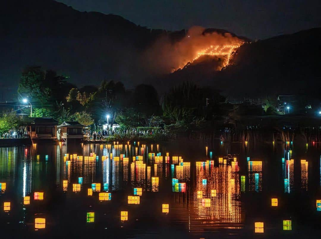 詩歩のインスタグラム：「📷 16th Aug 2023 📍 京都 五山送り火 / Kyoto Gozan Okuribi ,Kyoto Japan  京都に移住して3度目の #五山送り火 。 毎年8月16日に京都市で開催される、お盆の精霊を送る行事です。  有名な #大文字 を含めて全部で5つの送り火が灯されるのだけど、今年は唯一見たことがなかった #鳥居形 を見に行ってきました。  写真の場所は、嵐山エリアにある #広沢池 。灯籠流しが行われていてそのカラフルな灯籠と送り火を一緒に眺めることができます。  到着がギリギリになっちゃったので、これは三脚なしで撮影したもの📷   20時20分に点火された鳥居形は徐々に姿を表してきて、まずは合掌。ちょうど風に乗って灯籠も流れてきて、幻想的な光景が楽しめました🙏  去年は豪雨だったから今年は無事に開催されてよかった！やっぱり暑いので、来年からは家で涼みながらテレビで鑑賞しようと思います。笑  京都の写真はこのタグでまとめています / Posts of this area can be found in this tag.→ #shiho_kyoto   This is the third #GozanOkuribi (Bonfire of the Five Mountains) since I moved to Kyoto. It is an event held every year on 16 August in Kyoto City to send off the spirits of the Bon Festival. There are five bonfires in total, including the famous #Daimonji , but this year I went to see the #Toriiigata , which I had never seen before. The place in the photo is #HirosawaPond in the #Arashiyama area. The colorful lanterns and the bonfire can be seen together during the #lantern floating ceremony. This was taken without a tripod as we arrived at the last minute The torii fire, which was lit at 20:20, gradually came into view, and the first thing to do was to join hands. 🙏The lanterns were just flowing in the wind and we enjoyed a fantastic sight!  ©︎Shiho/詩歩」