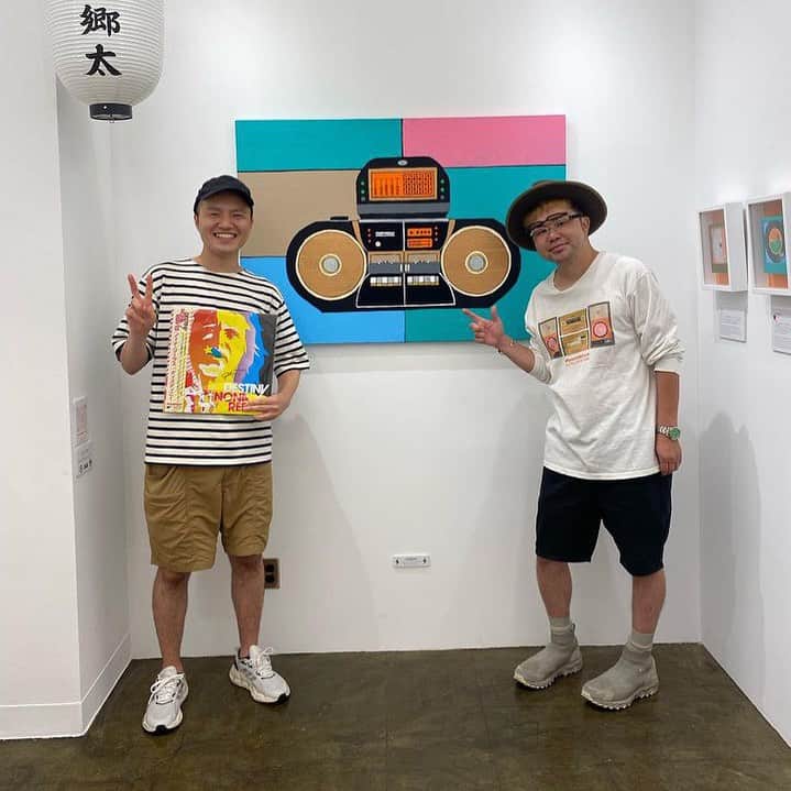 西寺郷太のインスタグラム：「今日18日金曜日、2023夏個展15時から20時まで急遽在廊します^ ^。  これまでだいたい一週間、長くて二週間という期間でしたが、今回はお盆休み真っ只中での開催ということ、ライヴなども重なりずっと在廊出来るわけでもないこともあり19日間という最長期間での個展となっています。  元々、レコードや本のショップ @hmvrecordshop_shibuya の中に出来たギャラリーということで、ちょっとしたポップアップストア的な趣きも強く、特別店員的佇まいで先週一週間通いましたが色んな人が会いに来てくれて本当に楽しかったです。  写真は最近ギターをお願いしている小林ファンキ風格 @kfukaku 君。まだ音源にはなってないけど、近いうちに必ず！」