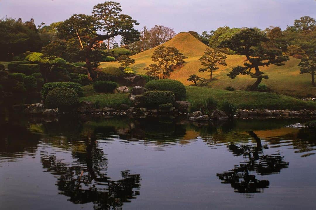 Michael Yamashitaのインスタグラム：「Summer note: At Suizenji in Kumamoto, a feudal lord loved viewing Mount Fuji so much that he recreated  Fujisan in miniature in his stroll garden, Suizenjijojuen. Japanese gardens may look their best in the rain as water awakens the greens. #suizenji #suizenjijojuen #kumamoto」