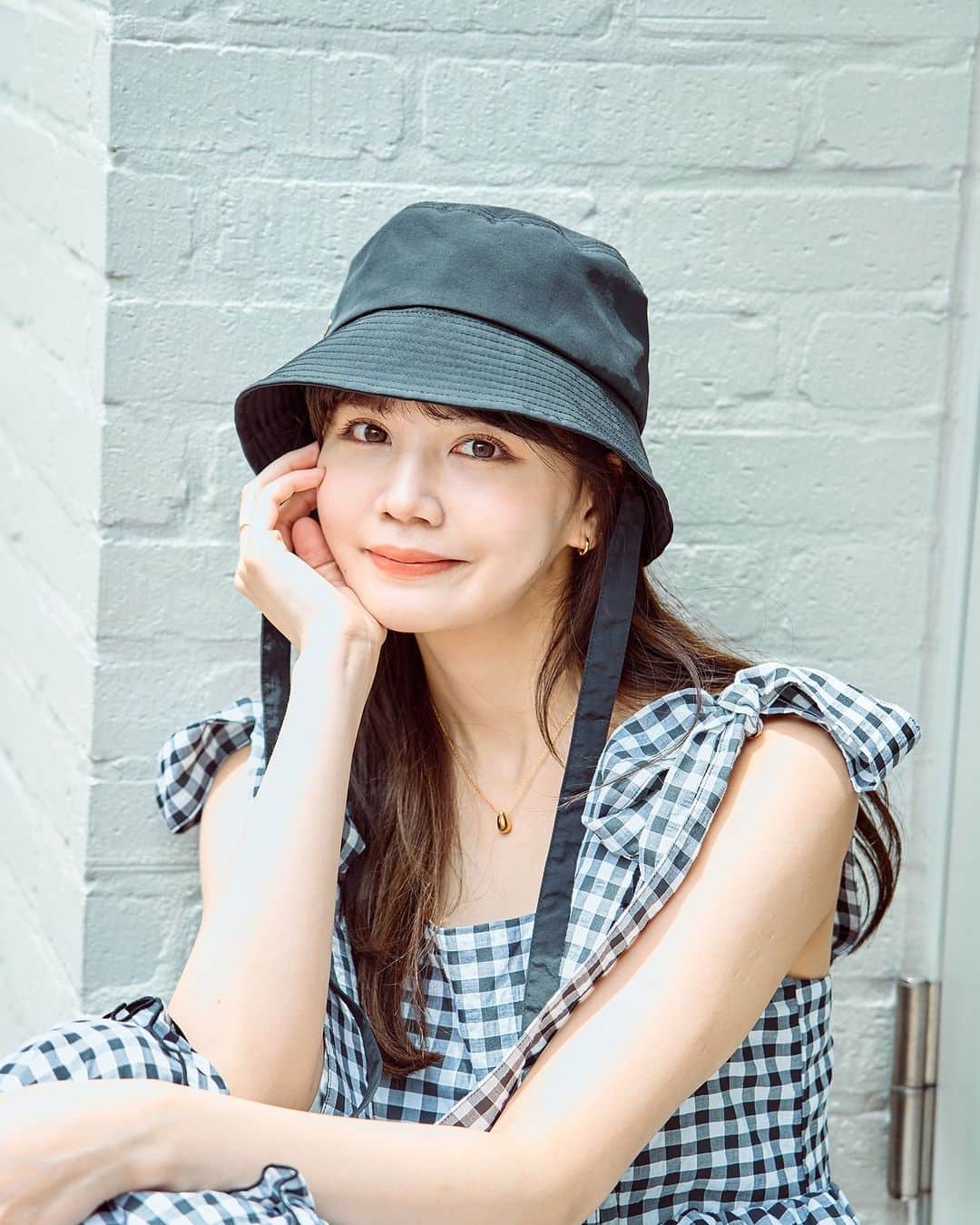 merのインスタグラム：「シックな色合わせに肌見せでヘルシーさを注入♥  今回は、村田倫子ちゃんの「チェック柄ワンピ」を使ったコーデを披露！  ☑肩のリボン、ギンガムチェック柄、ウエストや裾にあしらわれたフリルがフェミニン感満点！  ☑重ね着せずにあえて1枚で着て肌見せすることで、大人なヘルシーさを意識。  ☑フェスをイメージしてスポーティな小物を合わせつつ、全身ブラックで統一して甘さとクールさの絶妙バランスを狙ったのもポイント♡  その他、コーデの詳細はmer webでチェック🧚‍♀️」