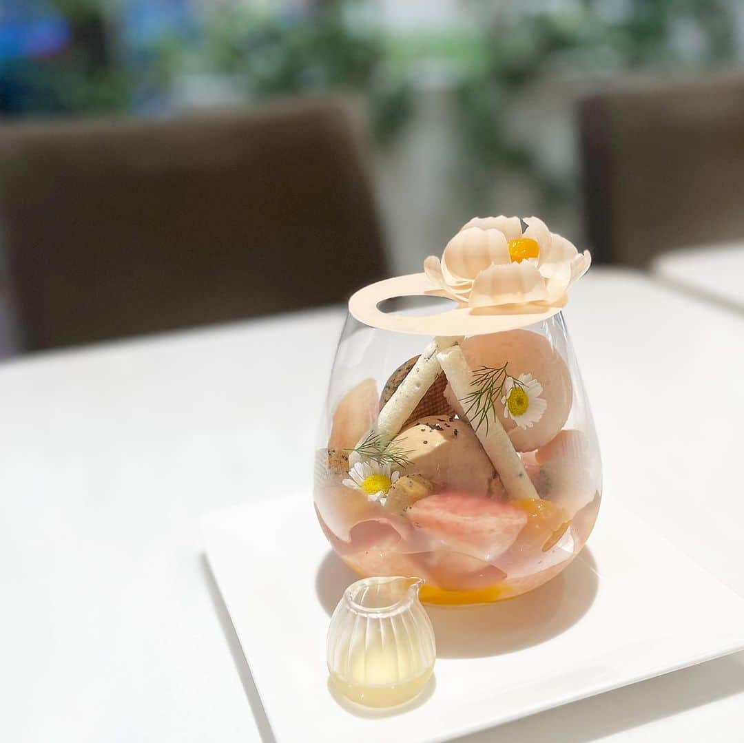 市川歩美さんのインスタグラム写真 - (市川歩美Instagram)「かわいらしいパフェ♡  パスカル・ル・ガック東京で「パルフェフルーリー ペッシュ」をいただきました。  桃のパフェです🍑  ホワイトチョコレートのお花がのったグラスの中には、紅茶のサブレ、シトロンミントのメレンゲ、桃のソルベ、紅茶のアイス、ドライアプリコット、山梨の農園から届いたフレッシュな桃など。  エルダーフラワーの風味や、添えられたディルが爽やかです。  かわいい女の子のような、ラブリーなピーチパフェでした。  このパフェは8月末まで限定、人気のため、事前に予約が必要です。  詳しくは @pascallegac_tokyo  をご確認ください。  #パフェ #桃のパフェ #パスカルルガック東京 #花ひらくパフェ #チョコレート #溜池山王カフェ」8月18日 21時15分 - ayumichocolat