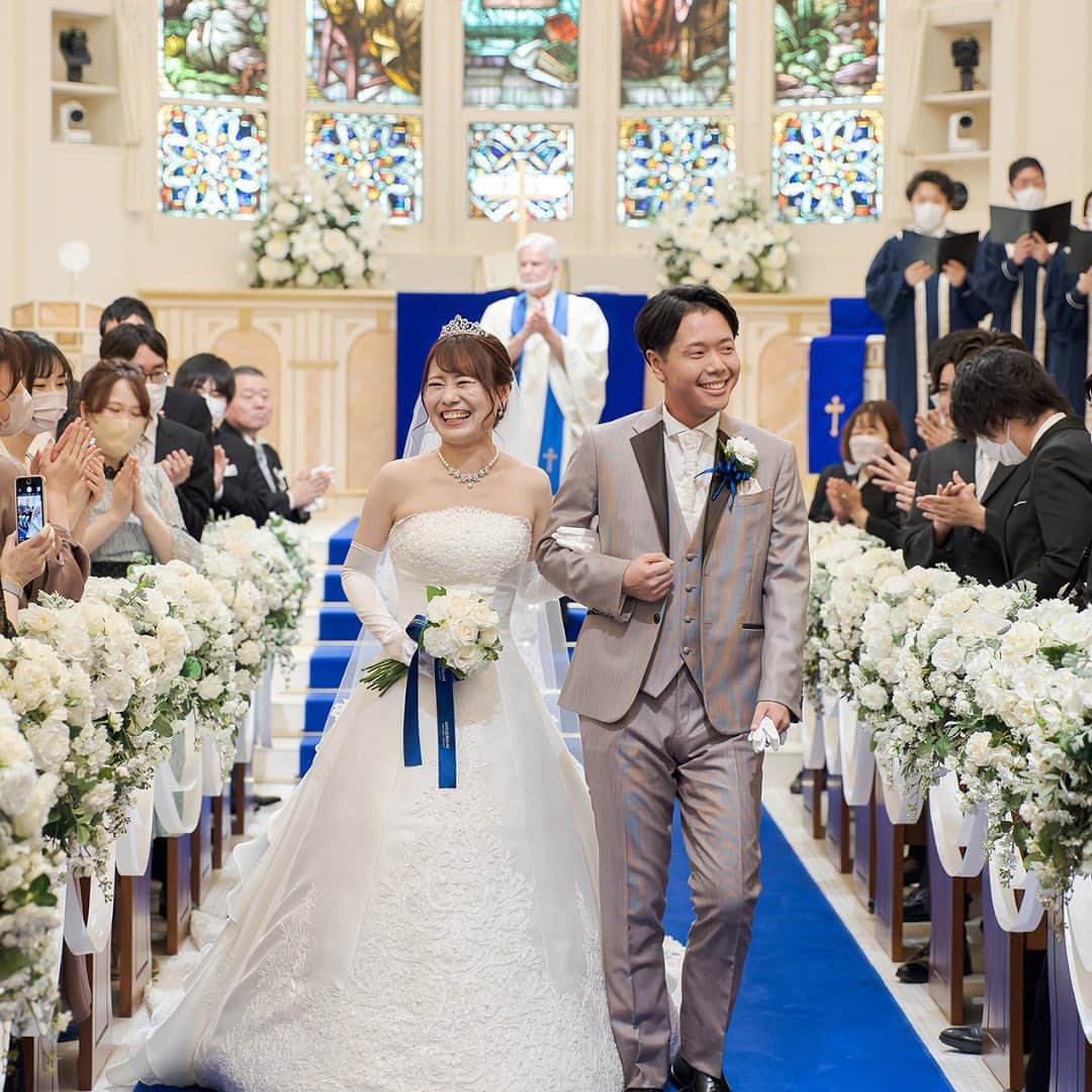 アニヴェルセル みなとみらい横浜 公式のインスタグラム：「． ． 本日は挙式のワンシーンのご紹介です✨  ゲストの皆様の祝福を受け おふたりはとても幸せそうな笑顔ですね🤍 大切なゲストの皆様に見守られながらの挙式は 一生の想い出となりますね🕊  ﾟ･*:.｡. .｡.:*･゜ﾟ･*:.｡. .｡.:*･ﾟ･*:.｡. .｡.:*･゜  横浜 みなとみらいの結婚式場 #アニヴェルセルみなとみらい横浜  📌海や空のように「永遠に続く」という 　意味を持つロイヤルブルーのバージンロード  📌120年の歴史が刻まれた 　壮観なステンドグラスのチャペル  📌好みに合わせて選べる 　7つの貸切披露宴会場  @anniversaire_minatomirai  👆詳細はプロフィールURLの 　公式HPよりご覧いただけます✨  ﾟ･*:.｡. .｡.:*･゜ﾟ･*:.｡. .｡.:*･ﾟ･*:.｡. .｡.:*･゜  #アニヴェルセル #アニヴェルセルみなとみらい #アニ嫁 #結婚式場見学 #ブライダルフェア #結婚式準備 #式場見学 #花嫁準備 #横浜花嫁 #みなとみらい花嫁 #みなとみらいウェディング #みなとみらい婚 #みなとみらい結婚式 #横浜結婚式場 #横浜結婚式 #神奈川結婚式場 #2023花嫁 #2024花嫁 #挙式 #チャペル挙式 #結婚式レポート #結婚式レポ」