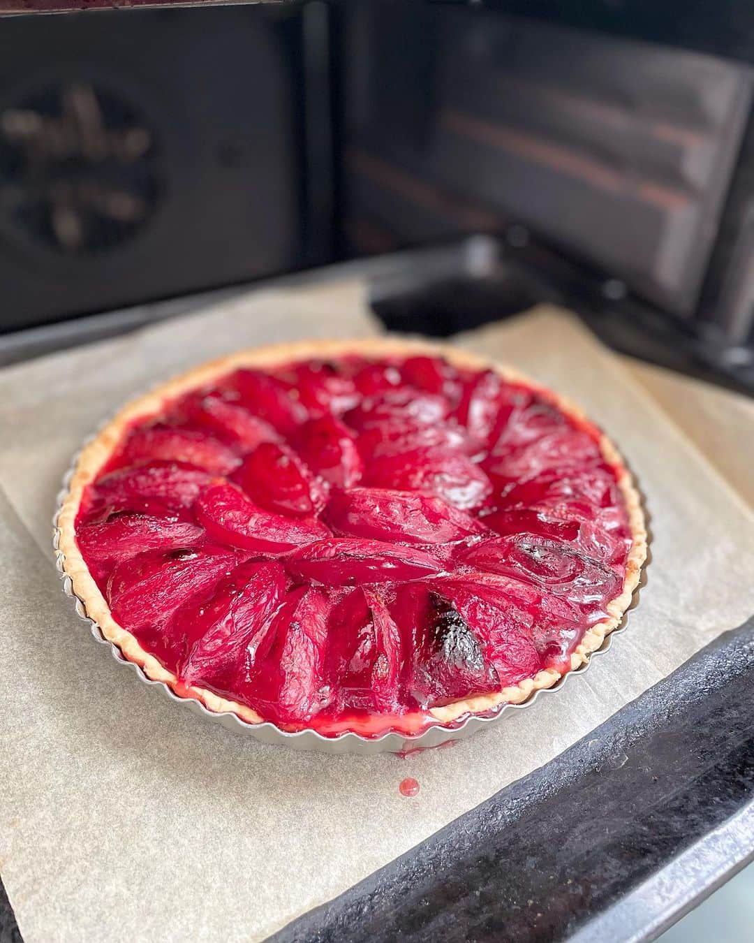 のインスタグラム：「バルセロナから戻って、ふたたび缶詰🥫の日々。  だがしかし、夏はまだ終わらない。そして世間のヴァカンスモードもまだまだ終わらない。  ふだんからのんびりしているおらがカルチエは、もう蝿が止まりそうなほど、さらにのんびりした空気が流れている🪰  その空気感だけ、ちょっと切り取って、仕事の合間の気分転換に、ひさしぶりのプラムの素タルトを焼く。もうプラムの季節なんだね👀  しずる✨焼き上がりの艶っぽさ  最近市販のでサボってた生地も、自分のレシピでササっとこさえて、豪放磊落にマリネしたプラムを詰めて焼くだけ。ポイントはすこしの粗挽き黒胡椒。  このタルトは、アイスクリームを添えて食べるのを前提に、本体の糖度はギリギリまで下げてある。プラムの自然の酸味を全面に出して、アイスクリームと合わせた時に、ジャストな甘みに感じられるように。  二度焼きしないフルーツタルトを私は素タルトと呼ぶ。低糖度で繊維質豊かで、旬の果物を活かしたヘルシーな日常のお菓子。  #猫沢飯　#ねこしき  #猫沢エミのインターナショナル五十路ライフシフト  #猫沢エミリーパリへ行く  #猫パリ　#ねこしきプラムの素タルト のレシピはこのタグの写真（ベランダとグリーン背景でアイスコーヒーと一緒に写っている）の写真に載ってます👀って見つけづらいのでストーリーズにリンクをupしときました😁」