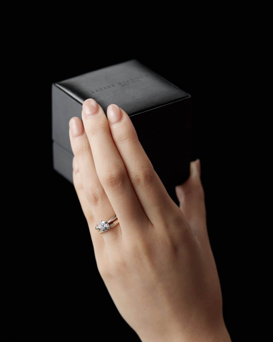 ラザール ダイヤモンド ブティック公式 | 婚約・結婚指輪のインスタグラム：「数あるジュエリーブランドの中でも、 “世界三大ダイヤモンドカッターズブランド” のひとつと称される ラザール ダイヤモンド。  ダイヤモンドの輝きに徹底的にこだわり、 歪みのない稀少な正八面体のオクタヘドロンを中心に、 厳選した原石のみを使用。  この美しさを秘めた原石に、理想的なカットである「アイディアルメイクを施し、最高峰の美しい輝きを引き出すことに徹底的にこだわっています。  無限に続く奇跡の輝きに酔いしれて。  ＜婚約指輪＞CARILLON ＜結婚指輪＞APPLAUSE YG  #lazarediamond #ラザールダイヤモンド #婚約指輪 #エンゲージリング #結婚指輪 #マリッジリング #NEWYORK #NYC #ダイヤモンド #ダイヤモンドリング #ブライダルリング #ブライダルリング専門店」