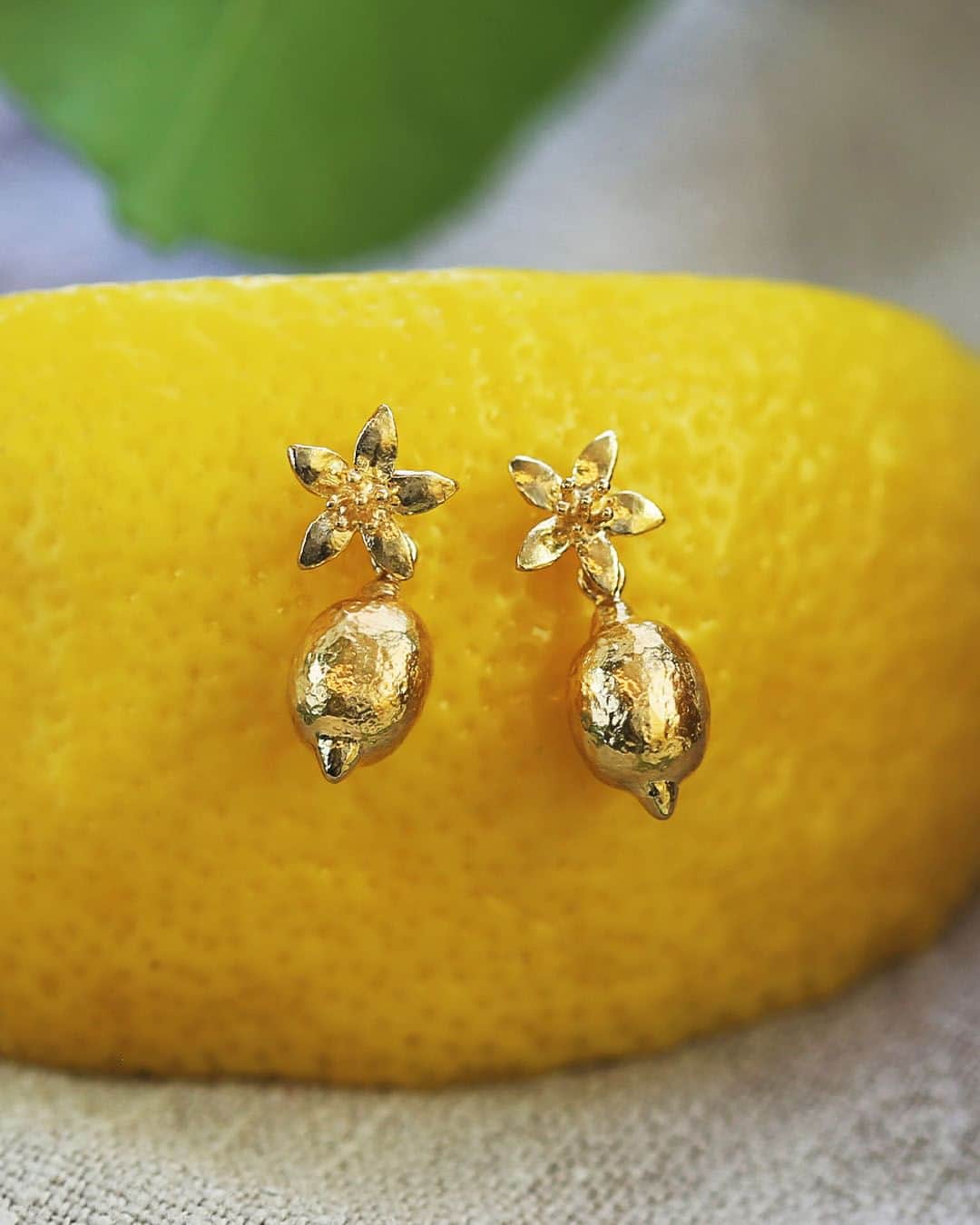 アレックスモンローのインスタグラム：「Luscious little lemons drop down gently from lemon blossom flowers, to form these pretty stud drop earrings 🍋  Want to find these beauties online? Click the link here: https://bit.ly/47t4d67  #AlexMonroeJewellery #ResponsiblySourced #FruitSalad #LaDolceVita #SummerNecklace #FairminedGold #InspiredbyNature #SS23 #NatureDesign #HandmadeinEngland #FruityJewellery #HandmadeJewellery #JewelleryDesign #SummerStyling #LemonEarrings」