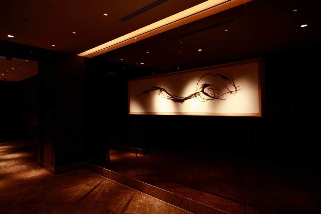 Shangri-La Hotel, Tokyoのインスタグラム：「館内を彩るアート作品の数々。⁣ ⁣ 「“流れ”と“対話”」と名付けられたこの作品を手がけるのは、東京に生まれ、現在シアトルを拠点に活躍するアーティスト、市川江津子氏。⁣ ⁣ 熱した物質で表面を焼いて表現する伝統的なアート技法のパイログラフを専門とし、熱くしたガラスを巻き取り、筆でドローイングするように描く独自の技法を用いた作品を数多く生み出しています。⁣ ⁣ 29階の通路を飾る躍動的に流れるこの作品は、「氣」のエネルギーを表現したものです。⁣ ⁣ Numerous works of art adorn the interior of the hotel.⁣ ⁣ At the corridor to Chi, The Spa on level 29, the dynamic work entitled “Flow and Dialogue” expresses the energy of 'chi' created by Etsuko Ichikawa, an artist born in Tokyo who is based in Seattle.⁣ ⁣ She specialises in pyrography, a unique art technique in which the surface is baked with a heated substance. ⁣ ⁣ Take a stroke in the hotel and find your favourite art piece.⁣ ⁣ #shangrilacircle #myshangrila #shangrilahotels #shangrila #shangrilatokyo #tokyotravel #tokyotrip #tokyostation #シャングリラ #シャングリラ東京 #シャングリラサークル #東京駅 #丸の内 #大手町 #市川江津子」