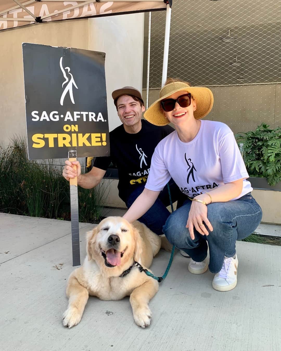 ブライス・ダラス・ハワードのインスタグラム：「Proud to rep @sagaftra on this National Day of Solidarity!! Today, across the country and across industries, we’re coming together to show that our movements for better compensation, safer working conditions, and fair contracts will not be beat! Our community is stronger than ever and we have hot labor summer to prove it 🔥🔥  [ID: Seth Gabel (left) and BDH (right) proudly wear their SAG-AFTRA shirts on the picket line. They crouch next to their golden retriever Story who visited them on the picket line for a morale boost.** Seth holds a “SAG-AFTRA on Strike!” sign while BDH pets Story. All three are smiling big in solidarity with the actors.]  ** It’s important to mention that because of the heat, I don’t recommend bringing pets to the picket line. Story’s visit was a special arrangement where she stayed less than 5 minutes, and in any other scenario she wouldn’t be there. Please take care of yourself and your fur babies in the heat!  #SagAftraStrong #Power2Performers #WGAStrong」