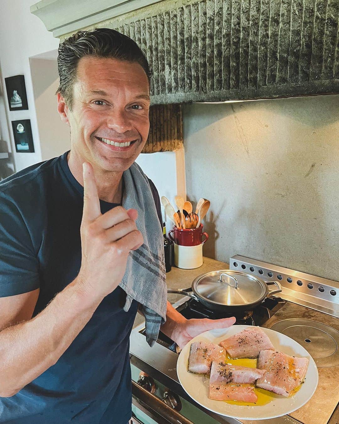 ライアン・シークレストのインスタグラム：「I love sea bass in the summer. It’s simple and a great opportunity to use quality extra virgin olive oil 🫒  Step 1 Put a little olive oil, salt, pepper, and herbs on the raw fish  Step 2 Separately cook some summer tomatoes with sage, basil, garlic, and olive oil in a pan  Step 3 Heat the pan. I use grapeseed oil when pan frying due to its high smoke point and its clean taste. Cook the fish skin side down until it’s cooked through (I like the skin golden brown and crispy) and add minced garlic.  Step 4 Add some lemon and fresh EVOO on top and enjoy!」