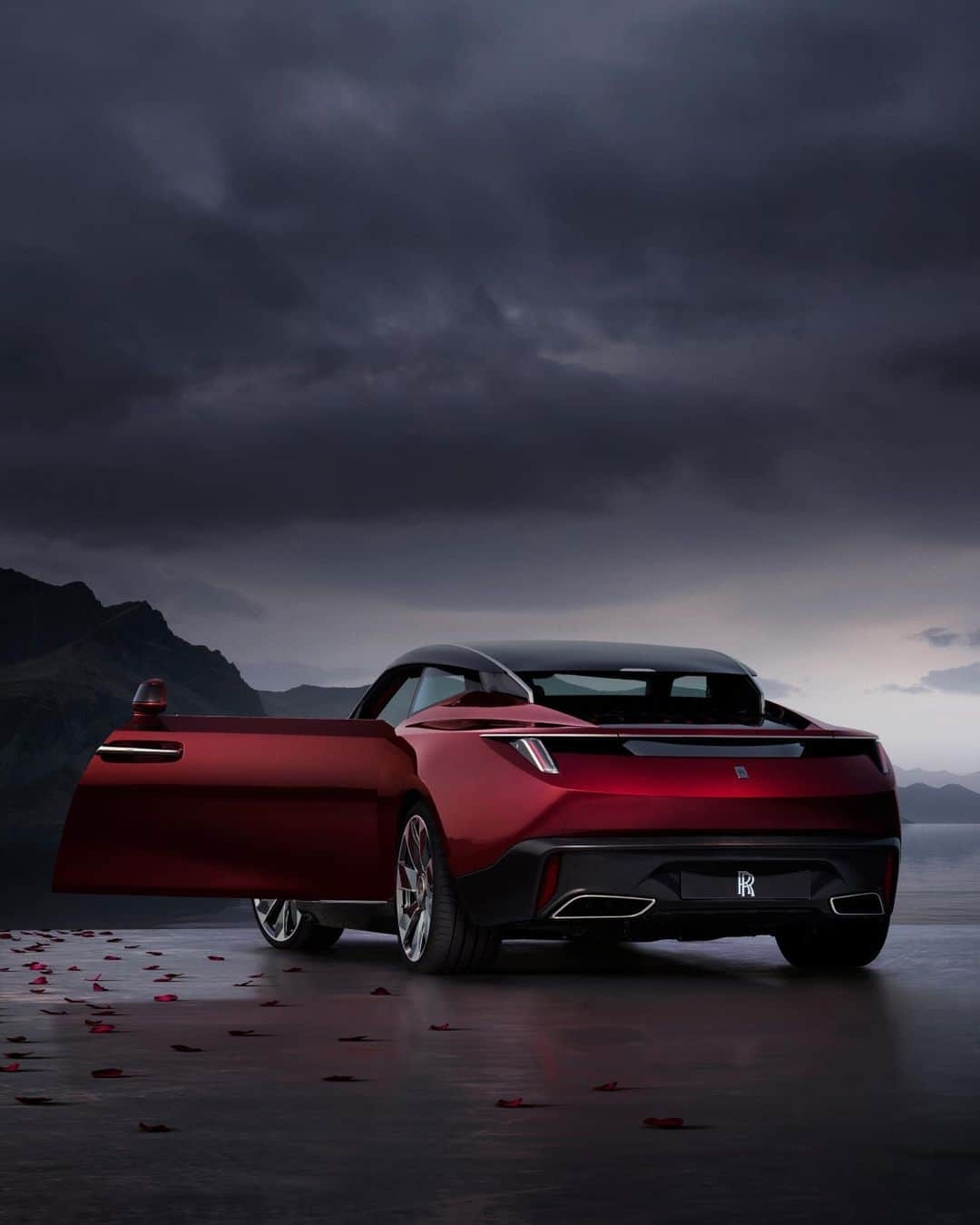 ロールス・ロイスのインスタグラム：「Rolls-Royce La Rose Noire Droptail encapsulates the infinitely changing palette of the Black Baccara rose. In sunlight, its velvet-like petals possess a red pearlescent shimmer. In shade, they read as black.  The lustrous and complex True Love exterior paint captures this colour-changing quality. In a completely new paint process, a base coat was followed by five layers of clear lacquer, each blended with a slightly different red tone to achieve the rose’s rich variation.   Discover more; link in bio.   #RollsRoyceDroptail #RollsRoyceCoachbuild #BespokeIsRollsRoyce」