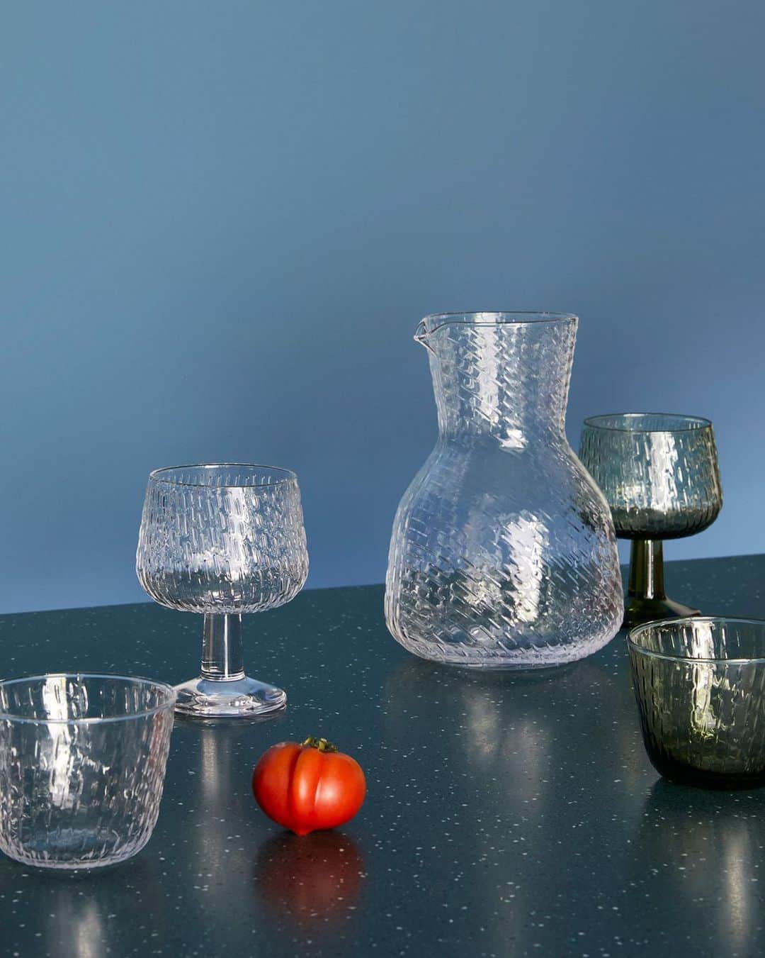 マリメッコのインスタグラム：「We're welcoming the season of misty mornings and gentle drizzle with the release of our new glass series, Syksy (autumn), by Swedish designer Matti Klenell. 🍂🌧️🤍  Bringing you a mouth-blown tumbler, goblet, and carafe, the Syksy series continues with the exploration of nature and weather phenomena familiar from our art of printmaking.  Explore the new collection. Link in bio. #marimekko」