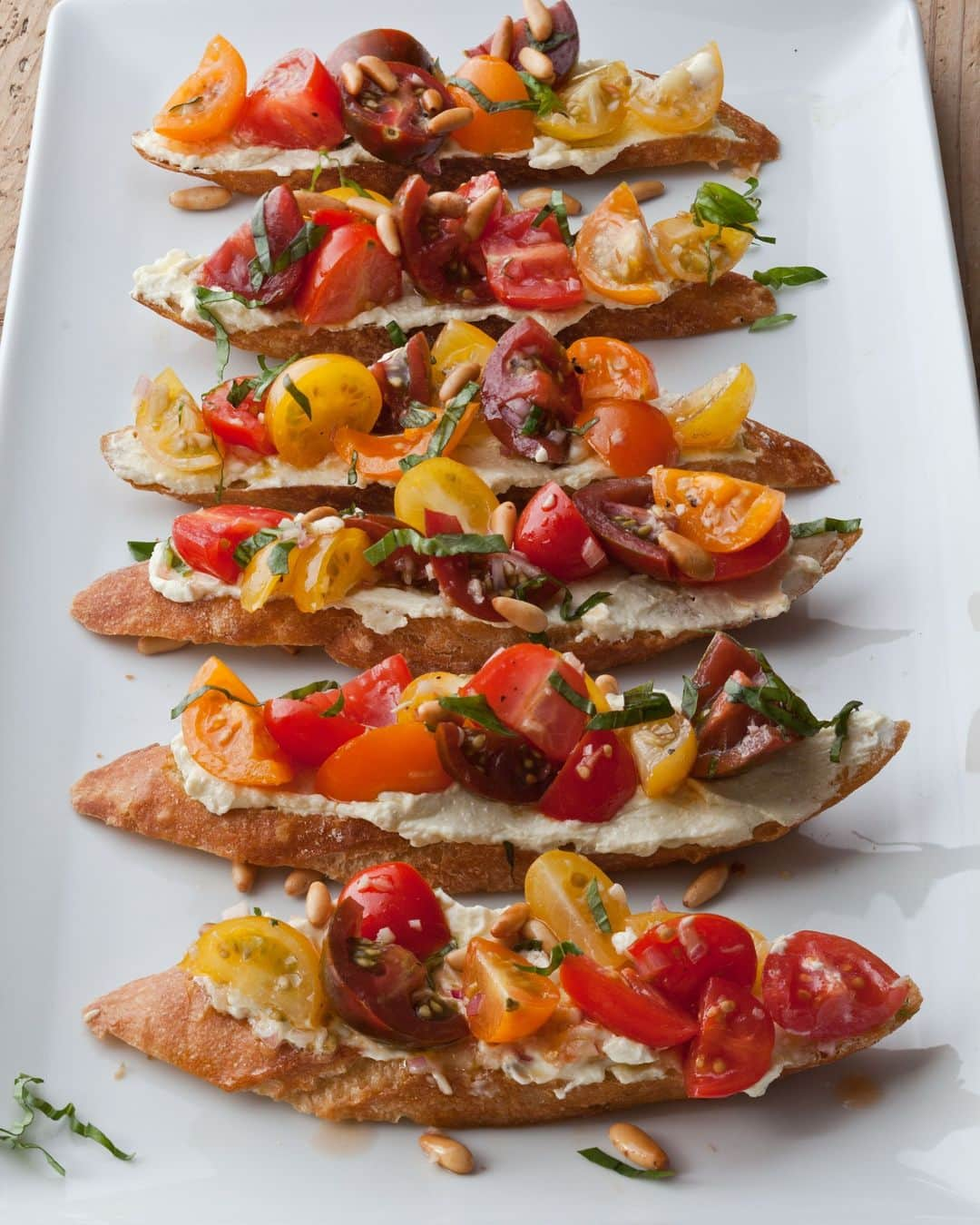 アイナ・ガーテンのインスタグラム：「Tomato crostini is one of my favorite appetizers. There's something about the crisp toast with the creamy feta and sweet tomatoes. The flavors and textures are so perfect and totally summer! Recipe linked in bio!  Barefoot Contessa Foolproof, page 66. 📸 @quentinbaconphoto」