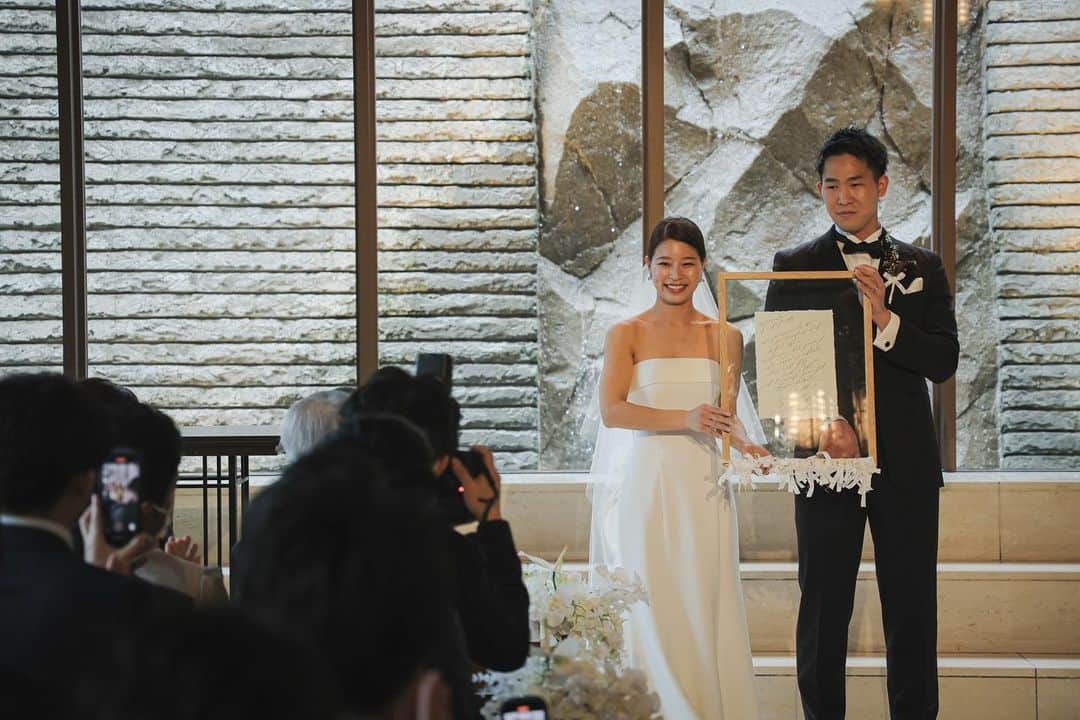 のインスタグラム：「.  Ceremony  人前式では参列したゲスト全員が おふたりの結婚の立会人となります  その承認の方法はおふたりのアイデア次第  おふたりがご準備されたのは ゲストおひとりおひとりのお名前が書かれたリボン   挙式がはじまる前に 結婚証明証のフレームに結んでいただくことで おふたりの結婚式の承認をする  それにより完成した結婚証明証を セレモニーの中でご披露されました  「これからも自分達と皆様のご縁を結んで お付き合いをしていきたい」 そんな願いも込められています  @oriental.hotel.kobe  @oriental.hotel.wedding  @kobe_laviephotography  @iwami_photography  @thetreatdressing  @treat_gentleman  @noritaka_igarashi  #ohk花嫁 #weddingbouquet #weddingdress #tuxedo #ウェディングドレス #タキシード #ウェディングブーケ #居留地 #thetreatdreesing #orientalhotel #orientalhotelwedding #オリエンタルホテル #オリエンタルホテル旧居留地」