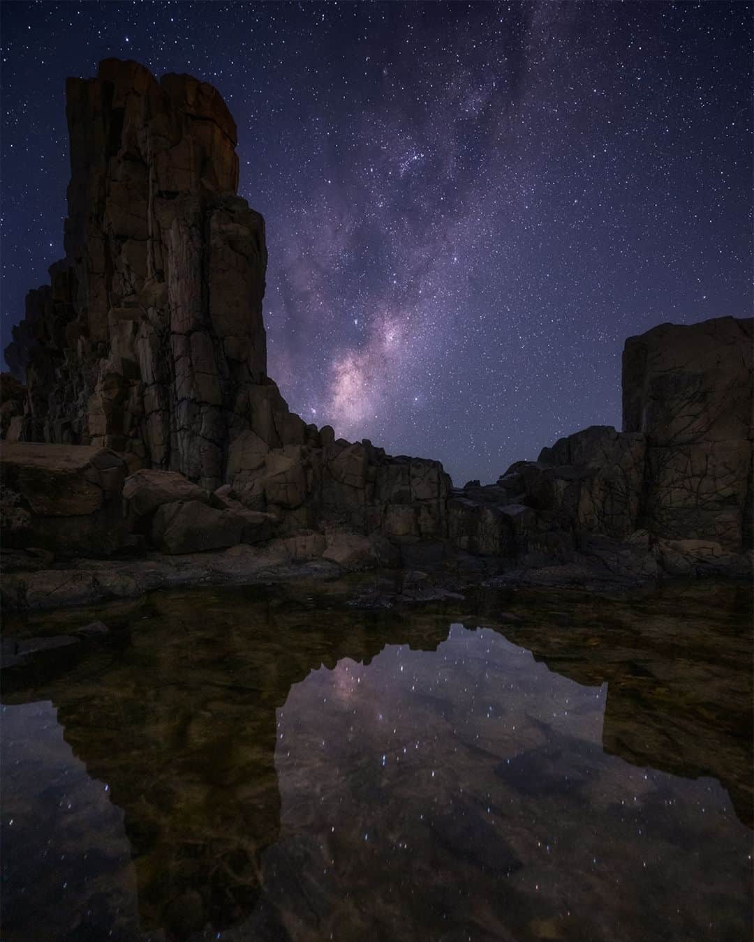 Nikon Australiaのインスタグラム：「Embracing Bombo's enchantment alongside friendly passing fishermen, @ivanzafiris_ skillfully captured the ethereal Milky Way, with a little help from the Z 7II's remarkable focus*.  "On this particular night, the conditions were perfect, a cloudless night with no moon and virtually no wind, the perfect combination for Astro Photography.  I didn't have any compositions in mind and navigating the rocky terrain at night in Bombo can be quite tricky and without the proper footwear can be dangerous. Luckily, I had some help from the passing fisherman who lit up the scene providing some direction and helping me locate a composition. So, with that, I proceeded to set up my camera and use Photo Pills to give me a good idea of where the Milkyway will be rising and at what time in relation to the scene I was planning to photograph.  For this composition, I wanted to get the beautiful reflections of the stars in the water including the amazing shadows of the Basalt Columns found scattered across Bombo. With the foreground completed, I had to wait for about an hour for the Milkyway to rise and be in the right position just behind the Basalt Columns.  The Nikon Z 7II has made my workflow for astrophotography so much easier. The focus to infinity when the Z 7II is turned on is such a time saver as I don't need to worry about focusing on stars when on location and the extended shutter allows me to take long exposures for my foreground without the need of an external intervalometer."  Photo by @ivanzafiris_  Captured on the Z 7II and NIKKOR Z 14-24mm f/2.8 S  *This image is a blended composite  #Nikon #NikonAustralia #MyNikonLife #NikonCreators #NIKKOR #Z7II #NikonZ7II #Zseries #LandscapePhotography #AstroPhotography #Australia」