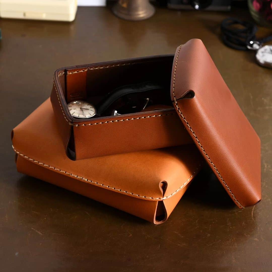 HERZ ヘルツさんのインスタグラム写真 - (HERZ ヘルツInstagram)「【新作】レザーボックス(KZ-5)　@herz_bag --------------------------------------------------------------------  ヘルツから新作 #レザーボックス 登場のお知らせです。  革の張りを活かした、ふんわりと丸みを帯びた立体的な形。 ふた付きボックスとしての用途はもちろん、ふた自体もトレイになるので、本体と合わせて2つのトレイとしてもお使い頂けます。  Sサイズは、時計やアクセサリー、イヤホンといった日々使う小物入れとして。 一回り大きいMサイズは、ハガキや洋2封筒が入るサイズ感。 Sサイズと同様、日々の生活で片づけにくい小物たちの収納ボックスorトレイとして役立ってくれます。　  皆様のアイデア次第で多彩な使い方で楽しめるレザーボックスです。  ヘルツ各店（Organを除く）で販売を開始いたします。 商品の詳細は商品タグもしくは @herz_bag プロフィールページのURLからご覧いただけます。  --------------------------------------------------------------------  #収納ボックス / #デスク周り / #ステーショナリー / #レザー文具 / #革のある暮らし / #革のある生活 / #革 / #レザー / #革製品 / #革小物 / #革雑貨 / #革小物 / #レザーアイテム / #レザー小物 / #レザーグッズ /  #革職人 / #作り手 / #ヘルツ / #ヘルツバッグ / #herz / #herzbag / #leather / #leatherbag」8月25日 11時11分 - herz_bag