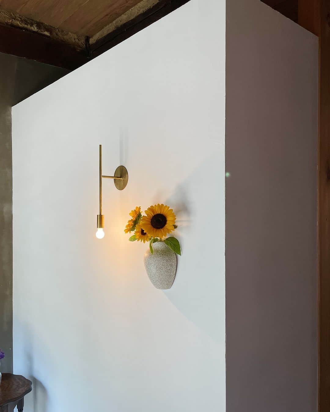 ムクリ［mukuri］さんのインスタグラム写真 - (ムクリ［mukuri］Instagram)「リノベーションで一からつくり上げた間仕切りのない土間続きの玄関  玄関ドアを開けた先に見える真っ白な壁。  壁を生かすシンプル且つ存在感がある照明 季節ごとに違った花が添えられる花器  「インテリアを楽しめる空間にしたい」 というrinaさんの思いが 小物一つ一つにも込められた玄関土間スペース。  LDKまで間仕切りのない土間続きの造りは 憧れていた京町家や古民家のような間取りを実現したもの。  土間の途中にある朽ちたレンガの部分は もともと古民家の台所があったところ。 既存のものをそのまま残し あえて完璧ではない独特の雰囲気を大切にしたリノベーション。  最近新しく設置された暖炉が 家族やお客様を温かく迎えてくれるようです。  玄関ならではの収納のお悩みも カーテンで緩く区切ったオープン収納で 見た目はスッキリ、空気もこもらずに清潔な空間になっています。  古民家の良さを最大限に引き出した 繋がりを感じる玄関土間のある暮らしをぜひご覧くださいね♪  –––––––––––––––––– ムクリ公式アカウントでは くらしの中にある"好き"や"コダワリ"を毎日お届け。  インテリア、整理収納から家づくりなど 日常で参考になる情報から サラッと読める短編コラムまで ご紹介していますのでフォローしてぜひご覧ください。 ▶︎ @mukuri_official ・  「 #ムクリ 」のタグもいつも楽しく拝見しています☺️  オリジナルブランドは @daily_mukuri  くらしの中にあったらいいいな、 そんな商品を企画・制作、集めています。 ––––––––––––––––––  #玄関#玄関インテリア#土間#モルタル#古民家リノベーション#リノベーション#古民家暮らし#古民家再生#土間のある家#土間のある暮らし#マイホーム#マイホーム記録#renovation#リノベ#丁寧な暮らし#暮らしを楽しむ#デザインラボ#勾配天井#半平家の家#梁のある家#くらしの編集#ムクリ」8月25日 21時05分 - mukuri_official