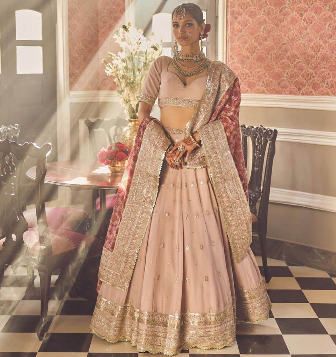 Indianstreetfashionのインスタグラム：「Embracing timeless elegance in shades of love and passion. 💖❤️ This stunning pink and red bridal lehenga is a symphony of colors that mirrors the emotions of a bride's journey. The delicate embroidery and intricate detailing on this masterpiece weave tales of tradition and modernity.  The soft pink hues symbolize grace, while the fiery red represents love and commitment. Together, they create a captivating visual narrative of a bride's transition from one chapter of life to another.  Every sequin, every stitch, and every bead reflects the dreams and hopes that come together on this auspicious day. It's not just a dress; it's a canvas of emotions, a testament to the enduring beauty of love.  In this ensemble, I'm not just dressed in attire; I'm adorned in a love story that will be etched in my heart forever. 💍👰 #BrideInBliss #LoveInLehenga #WeddingDreams @indianstreetfashion #indianstreetfashion Outfit @lashkaraa」
