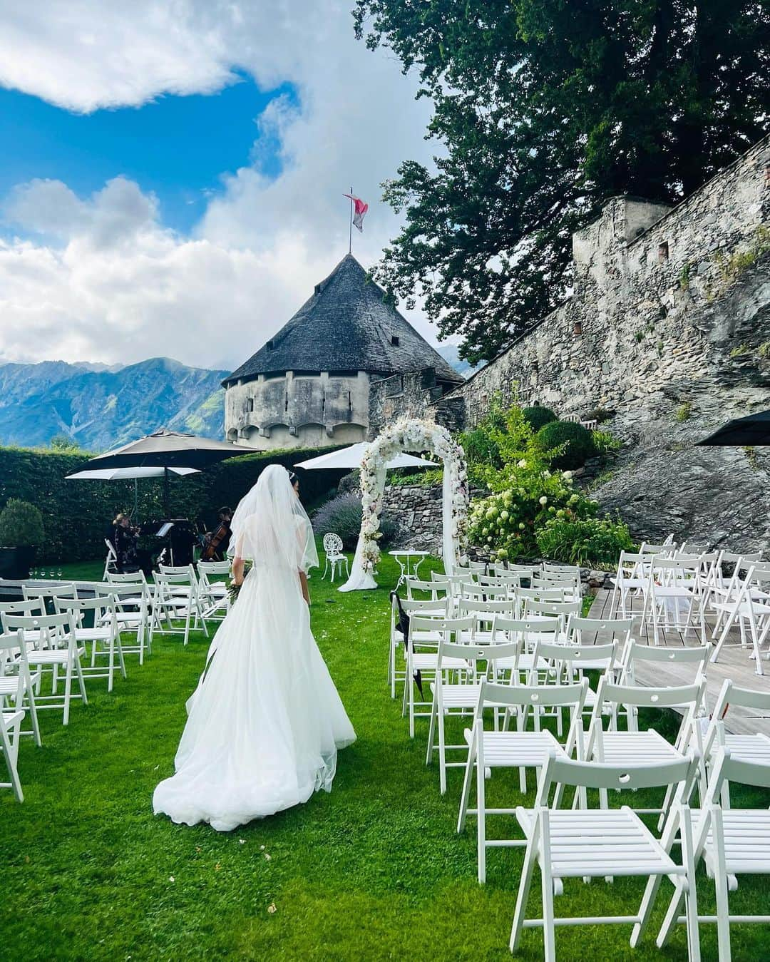 八木早希のインスタグラム：「チロルの伝統衣装は、地域と結婚未婚によってスカートの色やリボンの結び目などが変わるとのこと✨  香港で出会い暮らす新郎新婦💍 新郎の家族親族、友人らが地元で集い祝える喜びと感謝に溢れ、遠路訪れた私たちとっても、温かく美しいセレモニーでした🌿  10代女子とお揃いのドレスで✨新婦の介添人ができるなんて！💐  #結婚式#オーストリア#チロル#古城#親友#ガーデンウェディング#ガーデンパーティー#wedding#castle#weddingday#gardenwedding#austria#schlossfriedberg」