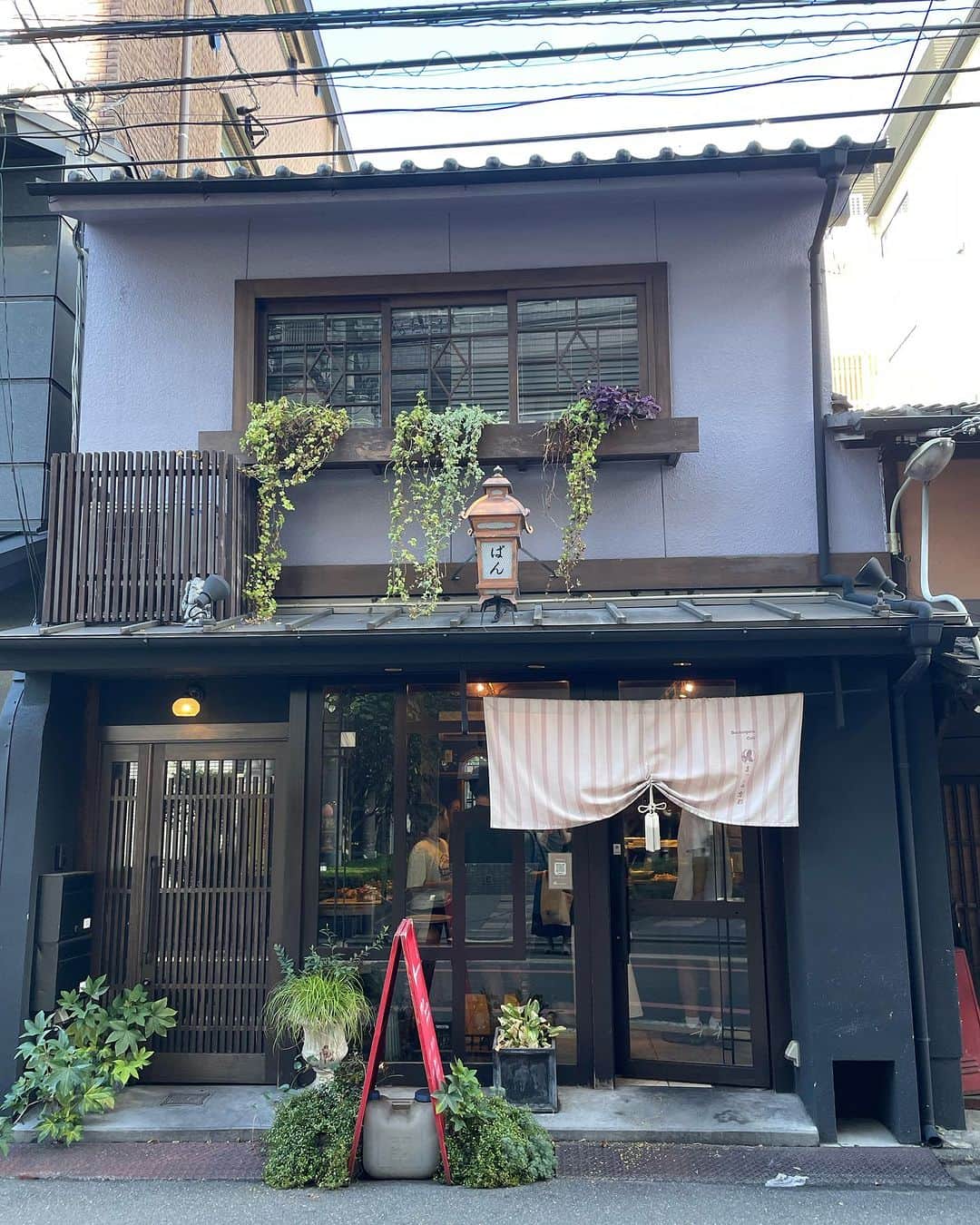 諸岡なほ子さんのインスタグラム写真 - (諸岡なほ子Instagram)「2日目の朝は、ホテルの近くの小さなお店でパンとカフェラテを調達。  boulangerie MASH Kyotoさんで、すみれの花がのったかわいらしい紫芋のあんぱん（自分用）、九条ネギのパン、抹茶のあんぱん（こちら２つは息子用）を。  カフェラテは前日に通りかかって気になっていたお店へ。  ホテルを出る前にストリートビューでお店の名前や、お店の名前がわかったらレビューまで見ておこうと思ったのだけど、最近お店が入れ替わったばかりらしく、ネットからはなんの情報も得られないまま行ってみることに。 せっかくの京都だし、貴重な一杯だし、できれば失敗したくないなーなんて思いつつ様子を伺ってみると、商品の並び方やお店の方の素敵な雰囲気で「大丈夫！」と確信。  聞くと、近くの老舗和菓子屋さんがあんこをおいしく食べてもらうためのスタンドとしてこちら、AoQ（青久）を運営されているとのことで、それだけに、こちらのカフェラテは先に買った紫芋のあんぱんとも相性バッチリでした。  前日がすき焼き食べ放題という育ち盛り男子ごはんだったので、朝はこれくらいがちょうどよく。  京都らしい味覚で軽快に2日目の旅を始められました。」8月26日 17時21分 - morookanahoko