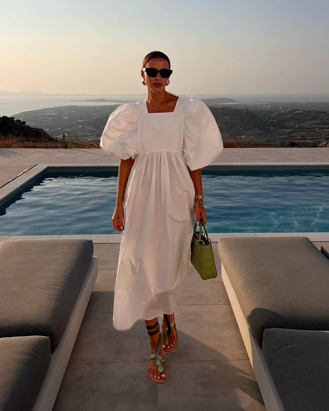 Zina Charkopliaのインスタグラム：「Adoring this exquisite and romantic dress, with its elegantly voluminous sleeves that add a touch of enchantment. It's been my go-to choice countless times this summer. Teamed up flawlessly with these stunning sandals, a cherished find from Naxos, and my beloved mint Lady Dior.  #Dior #Greece #Dress #Sandals #Style」