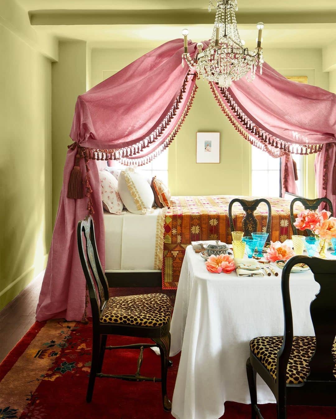 ELLE DECORのインスタグラム：「Welcome to the boudoir! Or—as hostess-with-the-mostest Rebecca Gardner (@housesandparties) calls it—a “turn-of-the-last-century brothel with a really fabulous madam.” Gardner’s apartment is teeny, but she made up for it by packing it with panache. Here in her bedroom (which she converts to a dining room by unfolding an eight-person table), she painted the walls in @farrowandball’s Churlish Green and draped her custom bed in a dramatic pink Busatti linen. Night cap, anyone?   Click the link in our bio for the full tour of this petite pad, as shown in our September 2023 Style Issue. Written by @katebolickate. Photographed by @annieschlechter. Styled by @bebehoworth.」