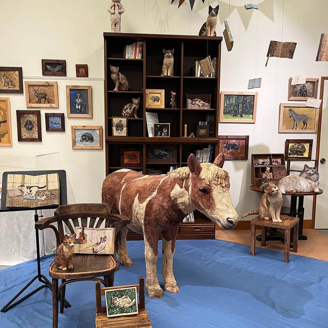 はしもとみおのインスタグラム：「佐賀県 唐津近代図書館での展覧会 折り返しも終わり9/10までとなりました。 図書室のコーナーは新作の本のレリーフたちをはじめ、本の椅子や無重力の本たちに世界中のいきものたちの詩が刻まれています。 大好きな図書館で、小さい頃住みたかった本の部屋の風景を再現してみました、本の中に住む動物たちに思いをはせていた小学校時代を思い出します。 ぜひ観に行ってみてくださいね。 展覧会は、さわれる子たちもたくさん遊びにきています。  #唐津近代図書館 #いきものたちの詩 #はしもとみお#展覧会 #図書館 #woodcarving #woodworking #sculpture #exhibition #art#animals #miohashimoto#sculptor」