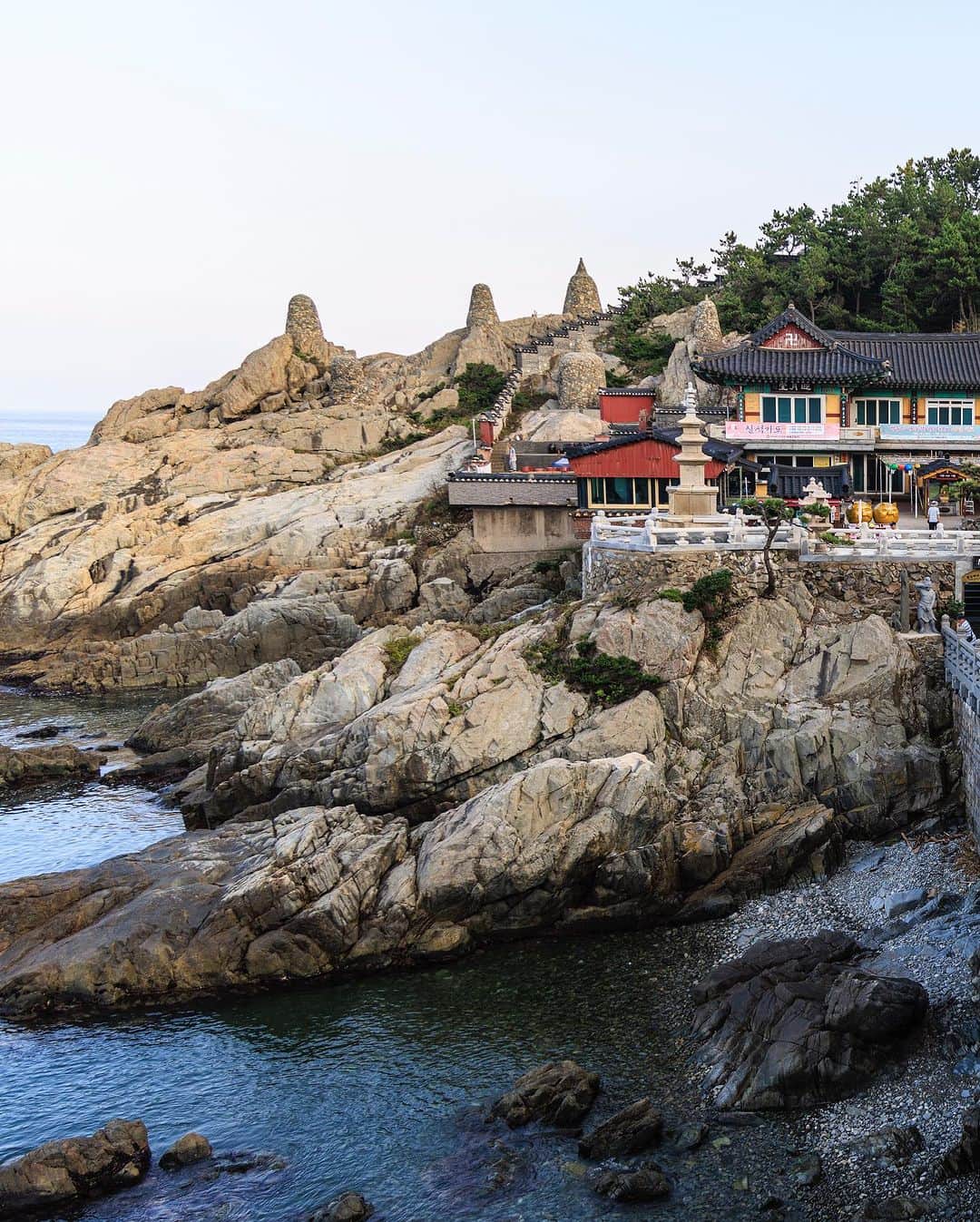 SHOCK EYEさんのインスタグラム写真 - (SHOCK EYEInstagram)「韓国でもせっかくなのでパワースポットと呼ばれている場所に行こうということで、  ”心から願えば誰でも必ず１つ願い事が叶う”  という、釜山の海東龍宮寺に✨  海岸沿いに建てられている為、まるで竜宮城のような雰囲気。 日本のお寺とはどこか趣きが違って、カラフルな色彩がとても綺麗で、何より海とお寺のコンビネーションが素晴らしい絶景を作り出していたよ✨  とにかく広いお寺さん、 至る所に沢山の仏像が置かれていて、見どころ満載✨  龍宮寺に向かう108段は、階段を下ると煩悩（ぼんのう）を取り去ってくれるそうだし、  橋の上から、幸運の小銭投げが できたり、  本堂横には縁起の良さそうな大きな布袋像。  何より目を見張ったのは海岸に鎮座する黄金色の地蔵菩薩かな✨🙏  優しい海風を受けながら静かにこの仏像の前に立ち手を合わせると、心がスッと整う感覚があったよ。  このお地蔵さまは、地獄の衆生を救済すると伝えられているんだって。  最後には階段を上り、、高台に立つこのお寺一番大きな、高さ10メートルほどの海水觀音大仏に手を合わせ、参拝は終了😌  異国の地でもこういった寺社を訪ねるのは本当に貴重な経験、時間になるよね。 楽しかった^ ^ 感謝感謝🙏  #海東龍宮寺 #釜山 #韓国 #해동용궁사」8月28日 15時06分 - shockeye_official