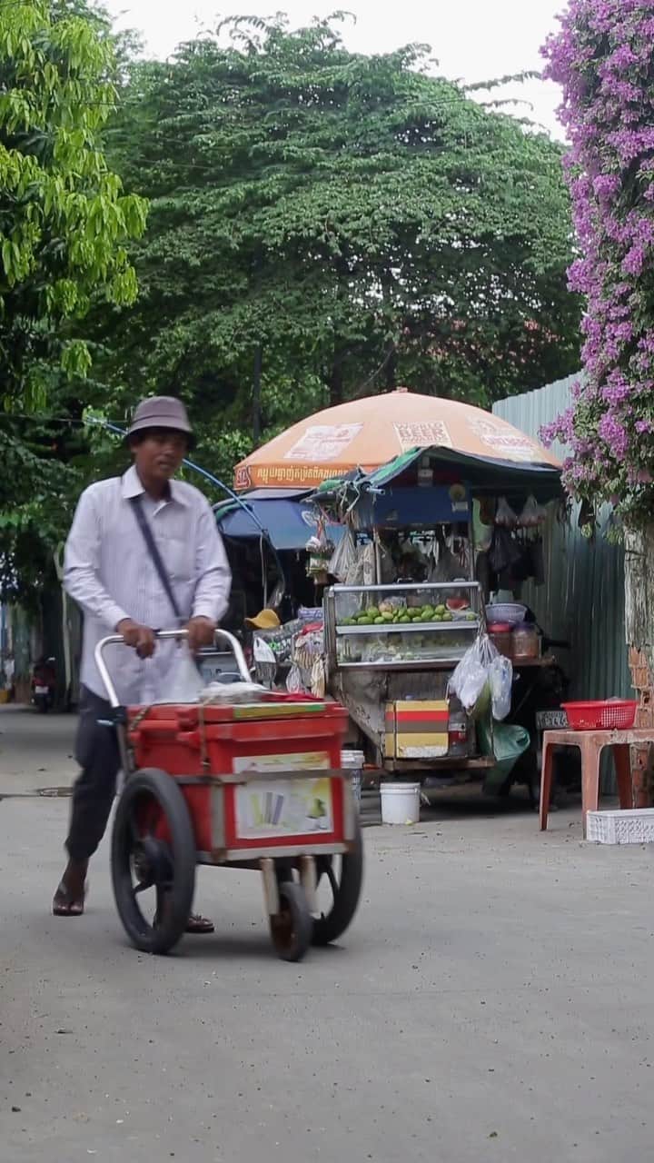 Shunsuke Miyatakeのインスタグラム：「A sound of a popsicle vendor's bell with layers of green trees and purplish pink flowers makes a slice of life on a tiny alley of afternoon Phnom Penh 😉  #PhnomPenhPhotographyCollective」