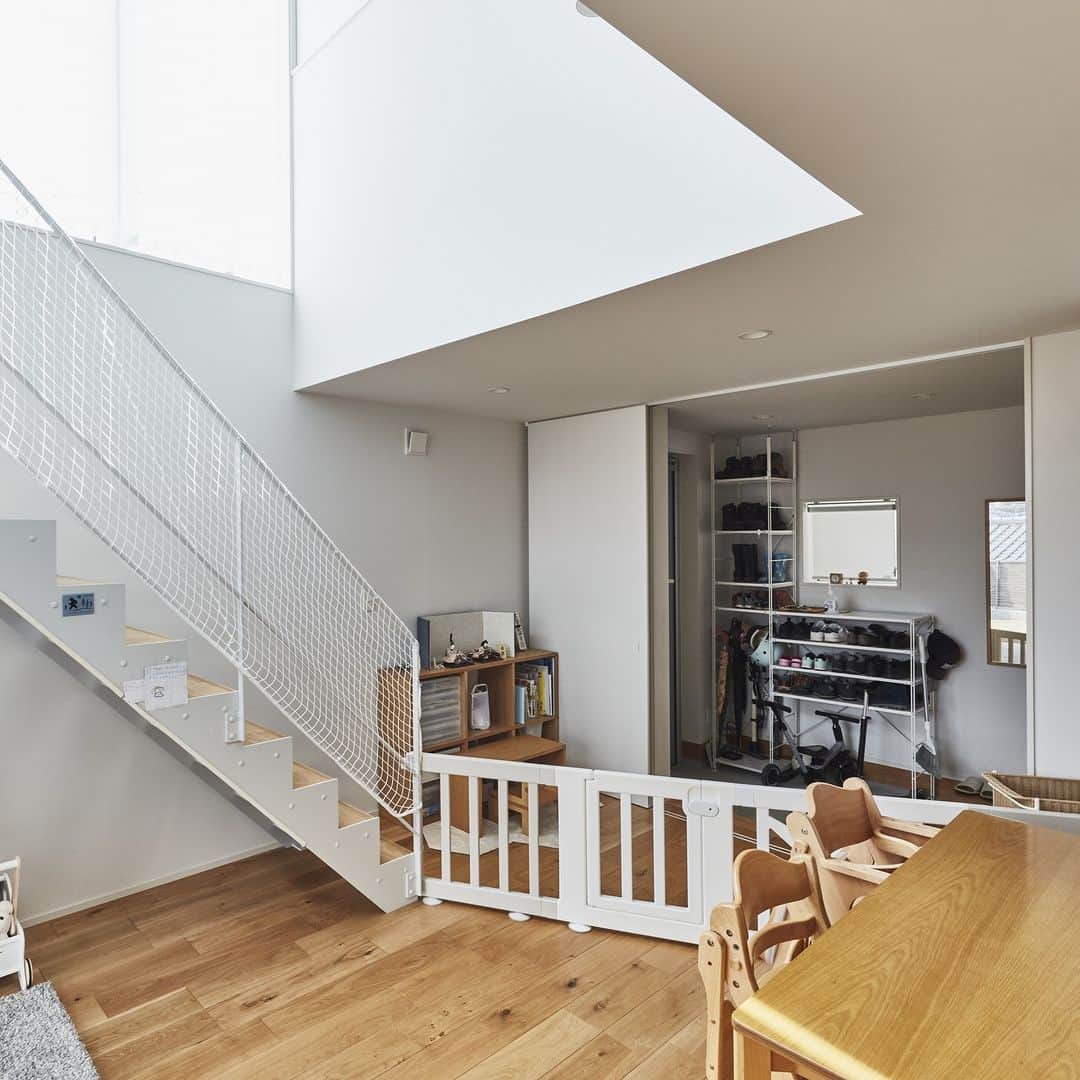 無印良品の家さんのインスタグラム写真 - (無印良品の家Instagram)「【住まいの実例】 ※右上のブックマークのアイコンをタップすると保存できます。  神奈川県横浜市 竣工年月：2020年5月 延床面積：100.19m²  横浜市にある「木の家」H邸は、白い壁が明るく映えるお宅。2面が道に面しているので見晴らしがよく、開放感が楽しめます。ご家族はこの家に住んで2年が経過しました。  都内にある店舗に行ったことがきっかけで「無印良品の家」を知ったというご夫婦。 家探しを始めた際に、真っ先に検討したのが「無印良品の家」だったんだとか。  「当初は『窓の家』にしたかったんです。でもこの土地の関係上、屋根部分が削れてしまうことがわかって断念。担当者と相談して、『木の家』を『窓の家』のようなインテリアにしていくことにしました」（ご主人）  「無印良品の家」の特徴は何と言っても、一般的なマンションやアパートとは違う間仕切りのない間取り。当初から「開放感があっていいな」と感じていた奥様に対して、ご主人は少なからず戸惑いや不安があったそうです。  「音や声が漏れることを心配していました。でも見学に参加し、すでに住んでいる方のお話を聞いたことで、不安はなくなっていきましたね。むしろこの間取りにチャレンジする楽しみが出てきました。リビングの床とウッドデッキの高さを揃えることで、窓を開放するとかなり広く感じることができて気に入っています」（ご主人）  玄関に大きな収納スペースを作ることも最初から希望していました。  「玄関から家に入って、まずは大きなスペースにいろいろ収納して、そこからキッチンの水周りに行けるのはとても便利です。子どもたちも外から遊んで帰ってくるとリビングに入る前に手洗いができる動線なので、衛生的にもいい。建てたのはコロナ禍前だったので意図した訳ではありませんが、結果的によかったですね。当初は施工例を参考に土間空間を広く取ることも検討しましたが、実際の暮らし方を考えると必要がないと思ってやめました。広く回遊できるように床で繋がっているほうが便利ですね」（奥さま）  2022.4.19公開住まいの実例『子どもの成長や家族の変化のたびにベストな家づくりを考えていくのが楽しみです』より  詳しくはプロフィールハイライトか、「無印良品の家」HPをご覧ください。  @mujihouse  #無印良品の家 #mujihouse #無印良品 #muji #無印良品の家_木の家 #施工例 #施工事例集 #おうちづくり #一戸建て #家づくり #間取り #施工事例集 #マイホームメモ #リビングインテリア #リビングダイニング #子どもがいる暮らし #ウッドデッキのある暮らし #回遊導線 #回遊できる間取り #間仕切りのない間取り #玄関収納 #玄関土間」8月28日 23時29分 - mujihouse