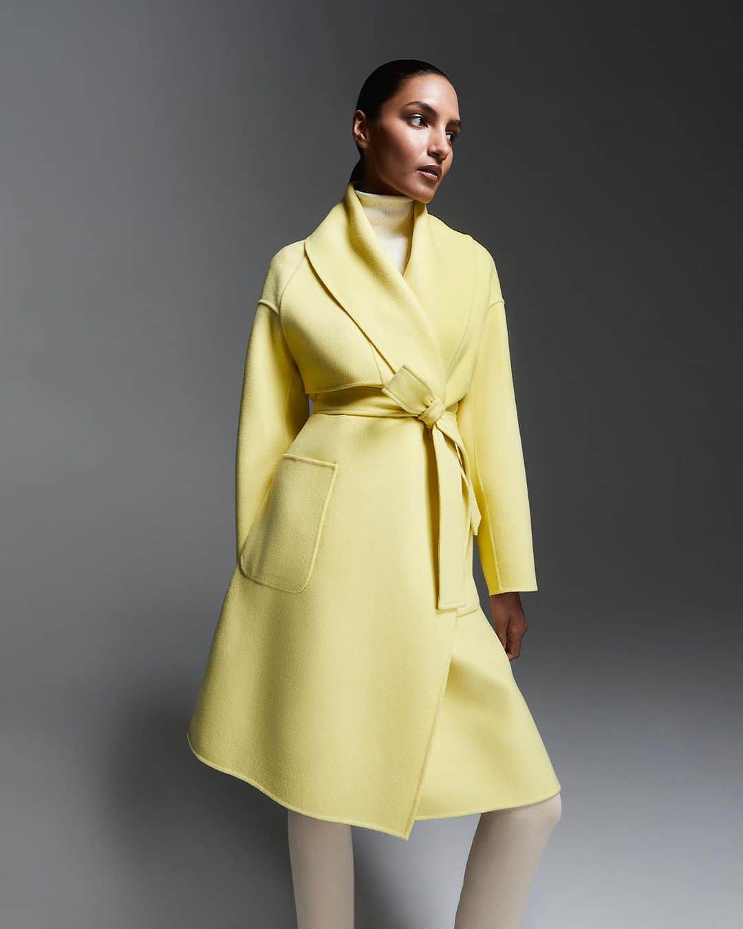 マッカージュのインスタグラム：「BRIGHT LIGHT    THALIA, a three-quarter wrap coat handmade from luxurious soft double-face wool. The cozy robe-style design and dropped shoulders offer elevated comfort while an asymmetrical storm flap, shawl lapel and oversized patch pockets add subtle eye-catching detail. Perfect for in-between seasons, the sash belt traps in warmth and accentuate a striking waistline.   More on MACKAGE.COM   #MACKAGE #MONDEMACKAGE」