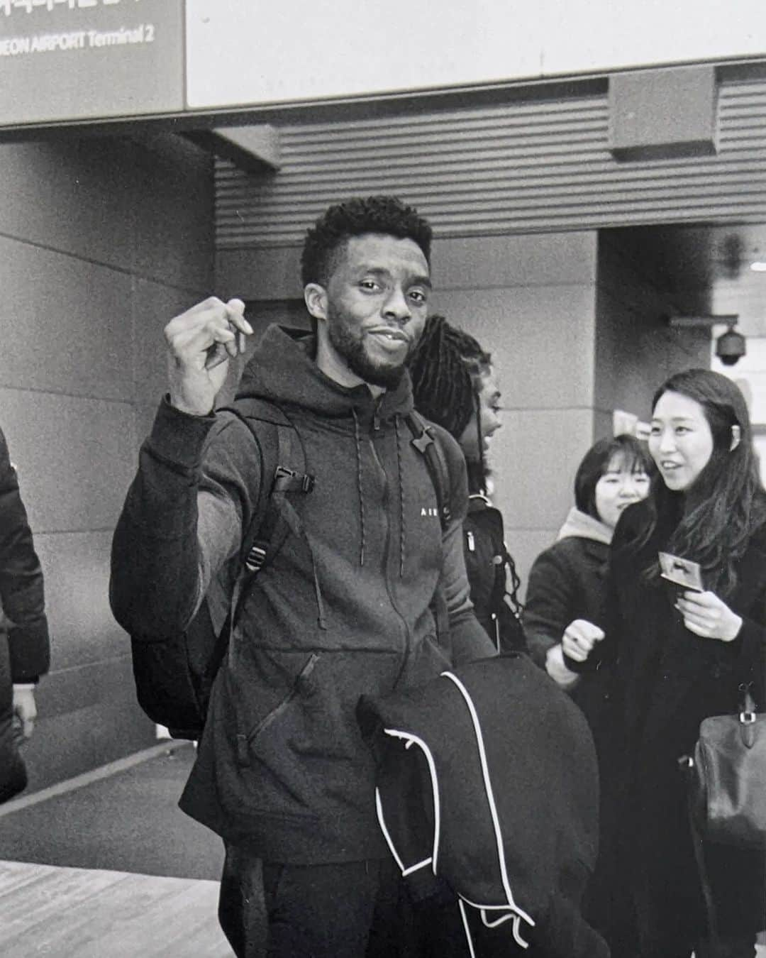 ルピタ・ニョンゴのインスタグラム：「Three years ago today, I experienced a singular pain at the news of @chadwickboseman's death. The confusion was so profound that it took months to trust the feeling of joy again.  : This is a photo I took on film at the airport as we arrived in South Korea in 2018. We had just learned to do the baby heart with our fingers. Here Chadwick was adding his suave flare 😊. We spent a glorious 72 hours there, and the memory fills me with so much joy.  : Death is hard to understand, maybe even harder to accept. But the love generated from the life he lived will fuel every anniversary marking his absence.  : Chadwick may no longer be in our photos, but he will always be in our hearts.」