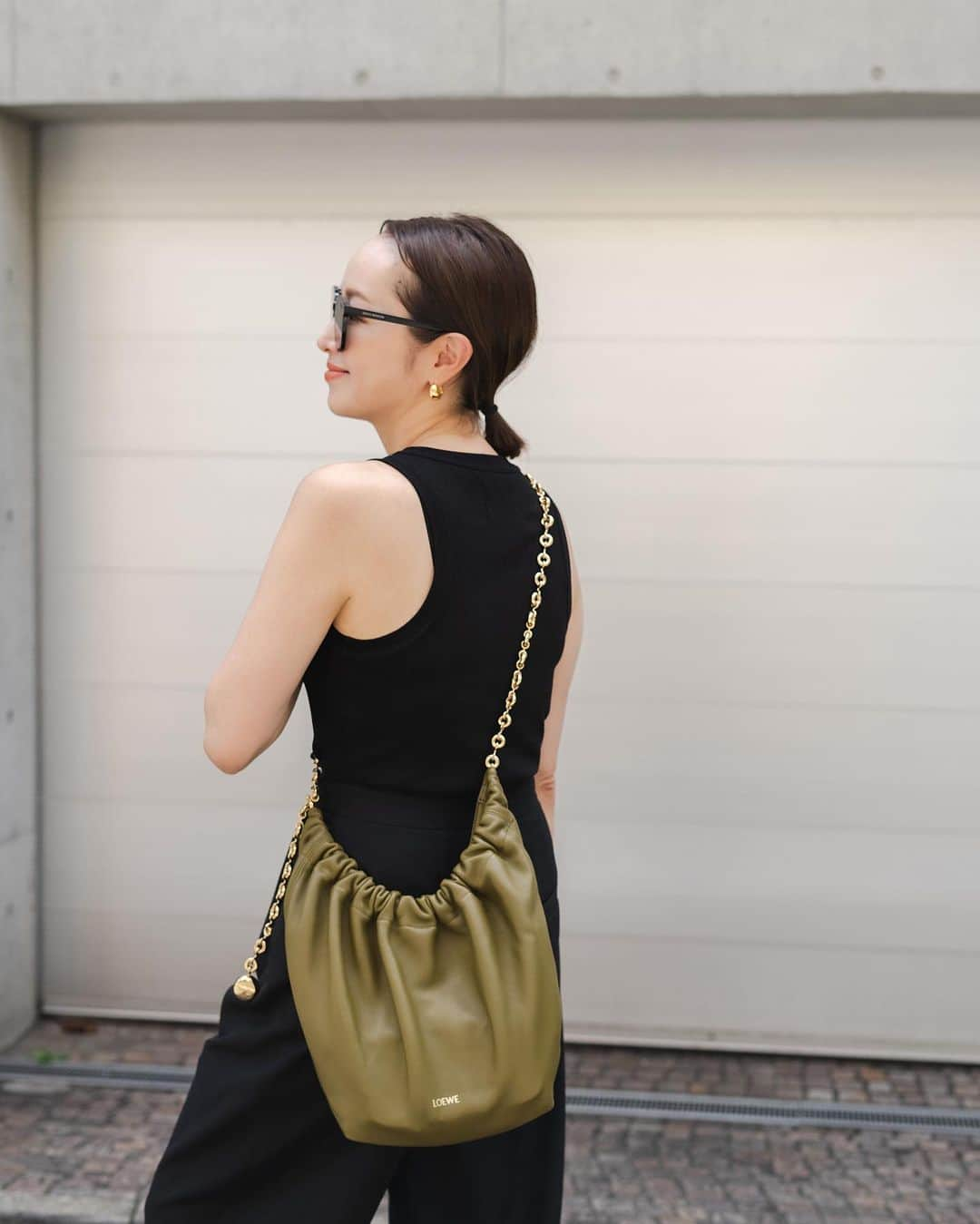 翁安芸さんのインスタグラム写真 - (翁安芸Instagram)「The first outfit photo since I came back to Tokyo with my new @loewe #LOEWEsqueeze by @jonathan.anderson ✨  子ども達の夏休みを終えて東京に戻ってから、久しぶりにマネージャーさんが撮影してくれたコーディネート写真。新しいロエベの「スクイーズ」バッグと🫶🏻  コレクションで見て以来ときめいていたこの新作バッグは、ハンドルの気持ちいい握り心地から、ギュッとする=スクイーズというのが由来だそうです🤎  上質な新素材メロウナパレザーの繊細なドレープが美しく、ドーナツチェーンで長さの調整ができるので、ハンドバッグ、ショルダーバッグ、斜めがけと簡単に様々なスタイルができるのも魅力✨✨  オリーブ色が新鮮で気に入っています🫒🤎  #LOEWE #LOEWESqueeze #ThanksLoewe #Tokyo #akiweng #ロエベ」8月29日 12時29分 - akinyc