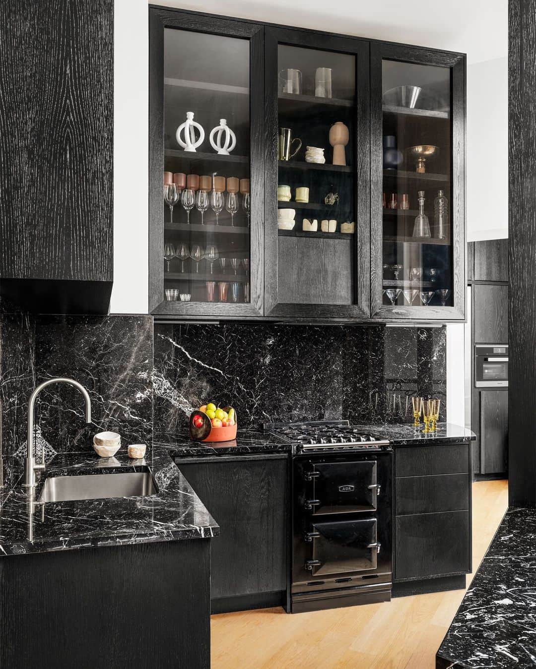 ELLE DECORのインスタグラム：「Move over, all-white kitchens: moody, dark cooking spaces are what’s hot. Look no further than this dramatic, deep-hued kitchen in a 1,900-square-foot duplex in Paris. The homeowner said she instantly fell in love with the apartment as it had atmosphere in spades. “It looked like something from a 1970s nightclub,” she says. “It was very cozy, like a cocoon.” Designer Pierre Gonalons (@galeriepierregonalons) maintained the kitchen more or less as it was, keeping the stained-oak millwork and black Marquina marble countertops and repainting some walls a pale blue. “I’m a firm believer that you don’t need to get rid of everything when redecorating an interior,” he insists.   To see more of this contemporary compound, as toured in our November 2022 issue, click the link in bio. Written and produced by @iangphillips. Photographed by @stephanjulliard.」