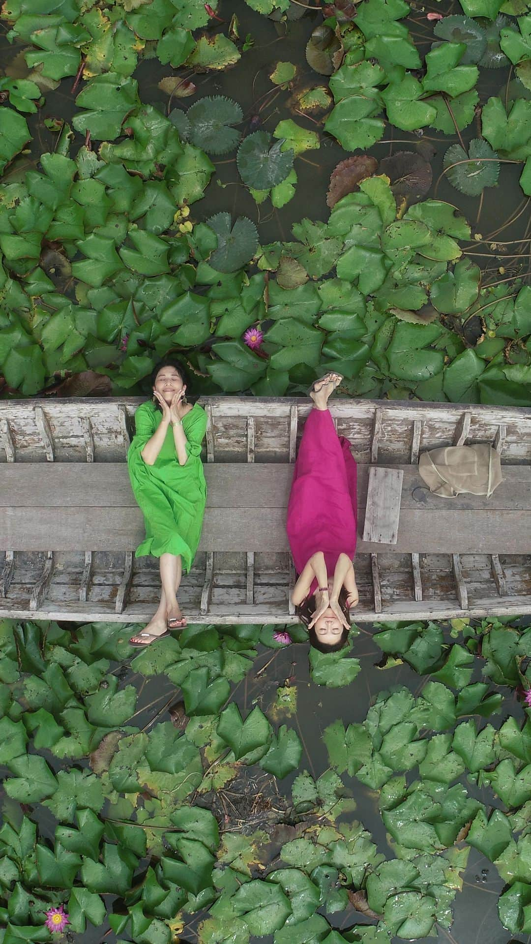 坂田陽子のインスタグラム：「バンコクから🚗で1時間半ほど。 ナコンパトムにある Red Lotus Floating Market ・ 一面に広がる蓮の花。 その蓮池を小型船で一周2〜30分。 陽気な船頭さんが記念撮影や、 なんと！ ドローン飛ばして上空からの撮影までしてくれるのです😆 ・ ここは比較的一日中楽しめるそうだけど やっぱり10時頃までが一番綺麗みたい。 とはいえ、午前中でもかなりの蒸し暑さ。 お水持参でボート乗り越むことをおススメします笑 なんてったって、撮影が結構ハード笑 ・ 蓮の花の間をぬって船は進み、 幻想的な雰囲気に浸っているのも束の間、 ポイントに到着するや否や 船頭さんから 息つく暇もなくタイ語（分からなくても全力でゼスチャーしてくれる）で指示がポンポン飛んでくる。 立ったり座ったり寝そべったり。 傘を持ったり持たなかったり。 顔に手を添えたり 怒った表情させられたり笑 いや、ロケか😆 ・ 途中、充電切れでドローンが船着場まで帰ってしまい、ボートに寝たまま暫く放置されるという場面もあったが そこもタイ😆🇹🇭でご愛嬌。 ・ 予め @tomoonly0811  のアドバイス通りワンピの色を相談していたお陰で なんだかんだで 蓮池に浮かびあがる色鮮やかな写真を沢山撮ってもらえ2人で500thb. 2千円位でこんな想い出フォト撮れるなんてコスパ抜群な観光スポット😍 ・ ボート代1人200バーツ ドローン撮影代100バーツ 傘はレンタル20バーツだけどサービスしてもらえた笑 ・ #redlotusfloatingmarket  #レッドロータス水上マーケット #蓮　#lotus  #蓮池 #バンコク映えスポット #ドローン撮影　 #instaphoto  #instatravel」