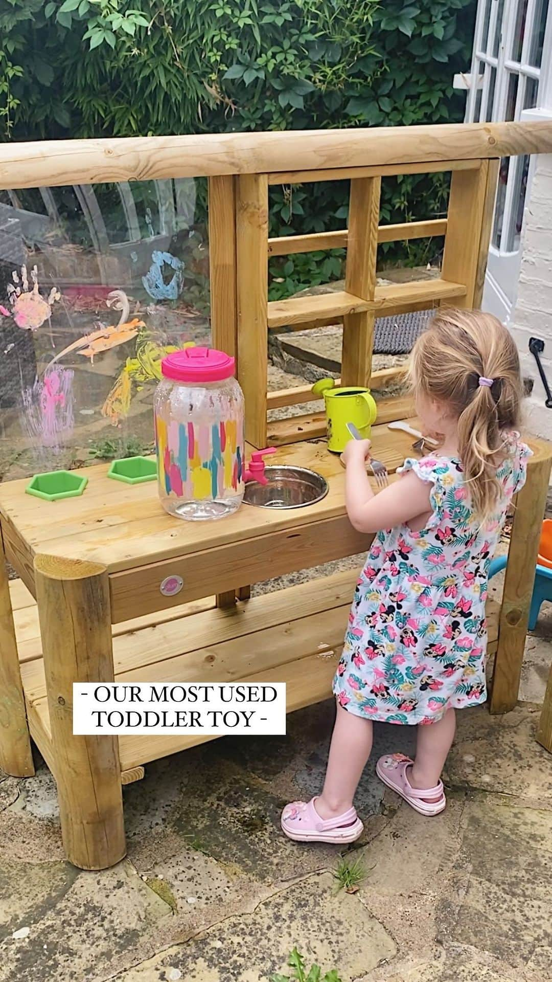 ローレン・ポープのインスタグラム：「OUR MOST USED TODDLER TOY! 🍴🫙🥣  Her little voice 😭🫶🏼😭 This mud kitchen has by far been our most used toy lately, it just has endless ways to be used. We’re currently making potions, perfumes and some ‘eggy’ lol with random bits from the garden and both girls love it but especially my toddler.   I got the water dispenser separately which was another hit, who would of thought a water tap could provide hours of entertainment 😂   One thing I will say though is it is tricky to build, it took 2 of us and needed a drill, you will need to drill nails and screws into wood that doesn’t have holes already which can be a bit fiddly but it is so worth it once it’s built! Plus it even has a wipe clean screen and comes with the paint pens.  Put them in some old clothes, let them run wild and get mucky in the garden whilst you put your feet up with a cuppa! What more could you ask for 🤪   Mud kitchen @scandiborn *ad/gifted  Water dispenser @therangeuk (£7 btw!)   What’s your most used toy?!」